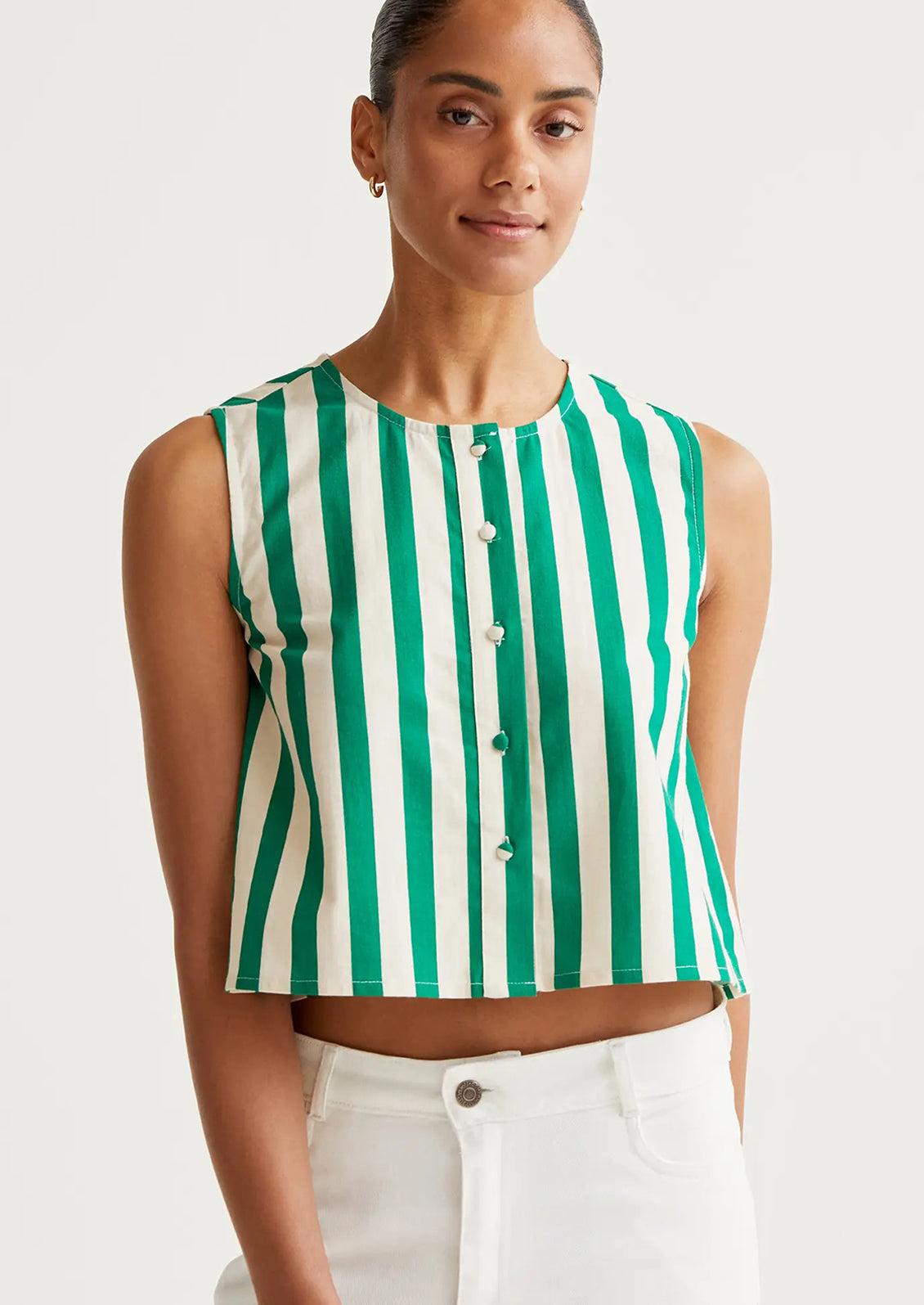 A person wearing a shell tank top with green and white vertical stripes.