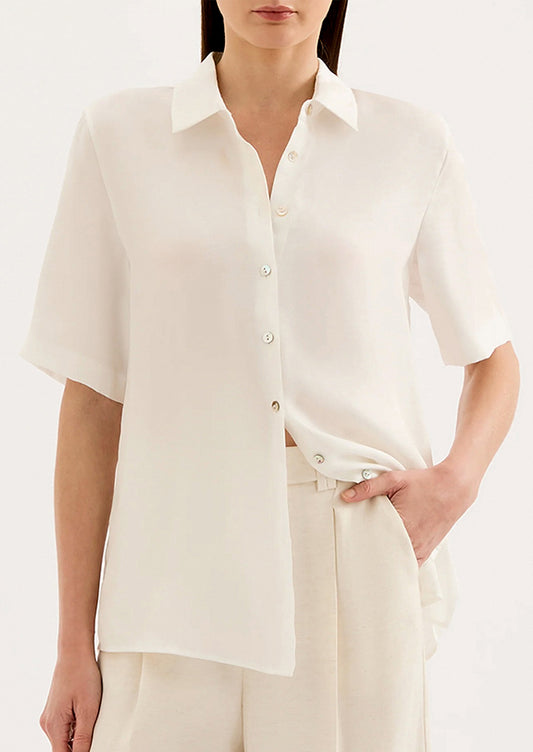 Woman wearing a white blouse with a plain background