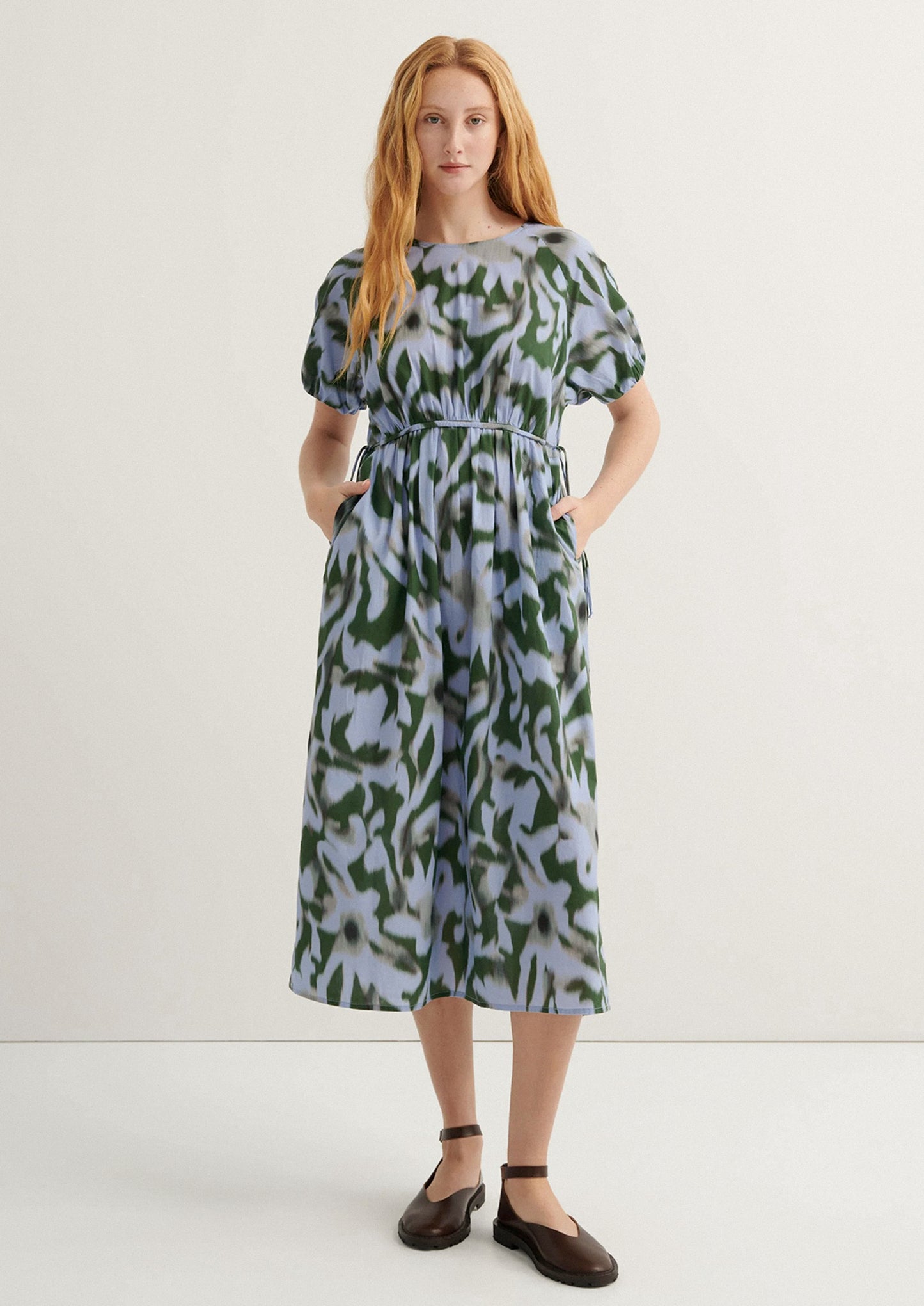 Woman wearing a patterned dress on a white background