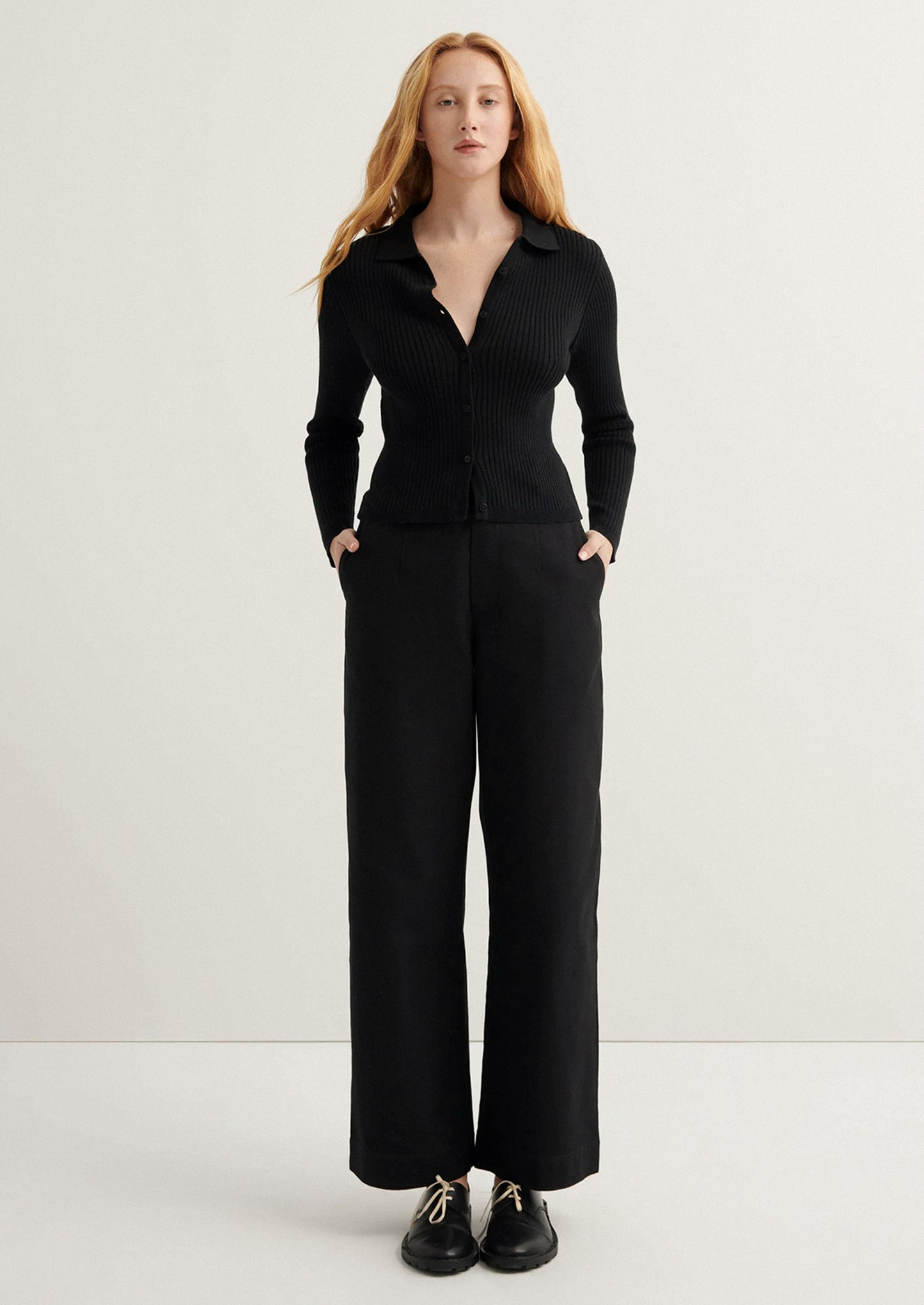 Woman wearing a black suit on a white background