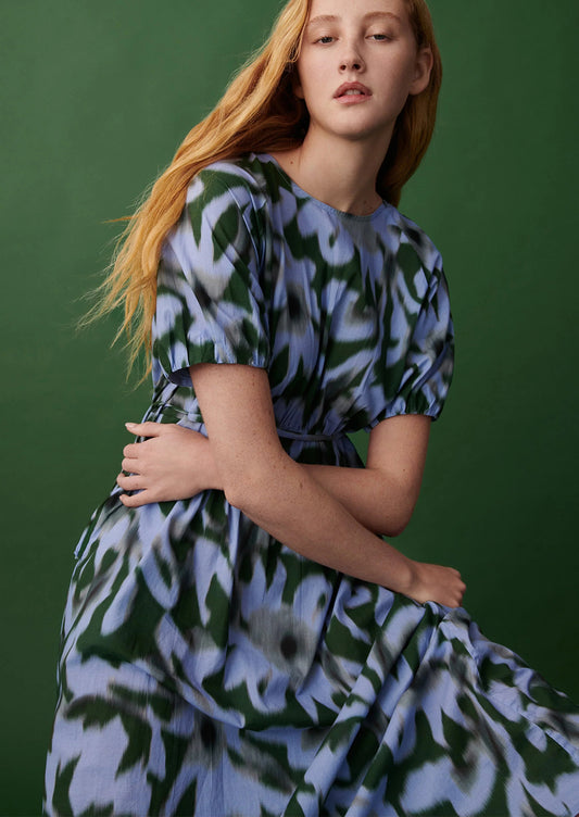 Woman wearing a floral dress against a green background