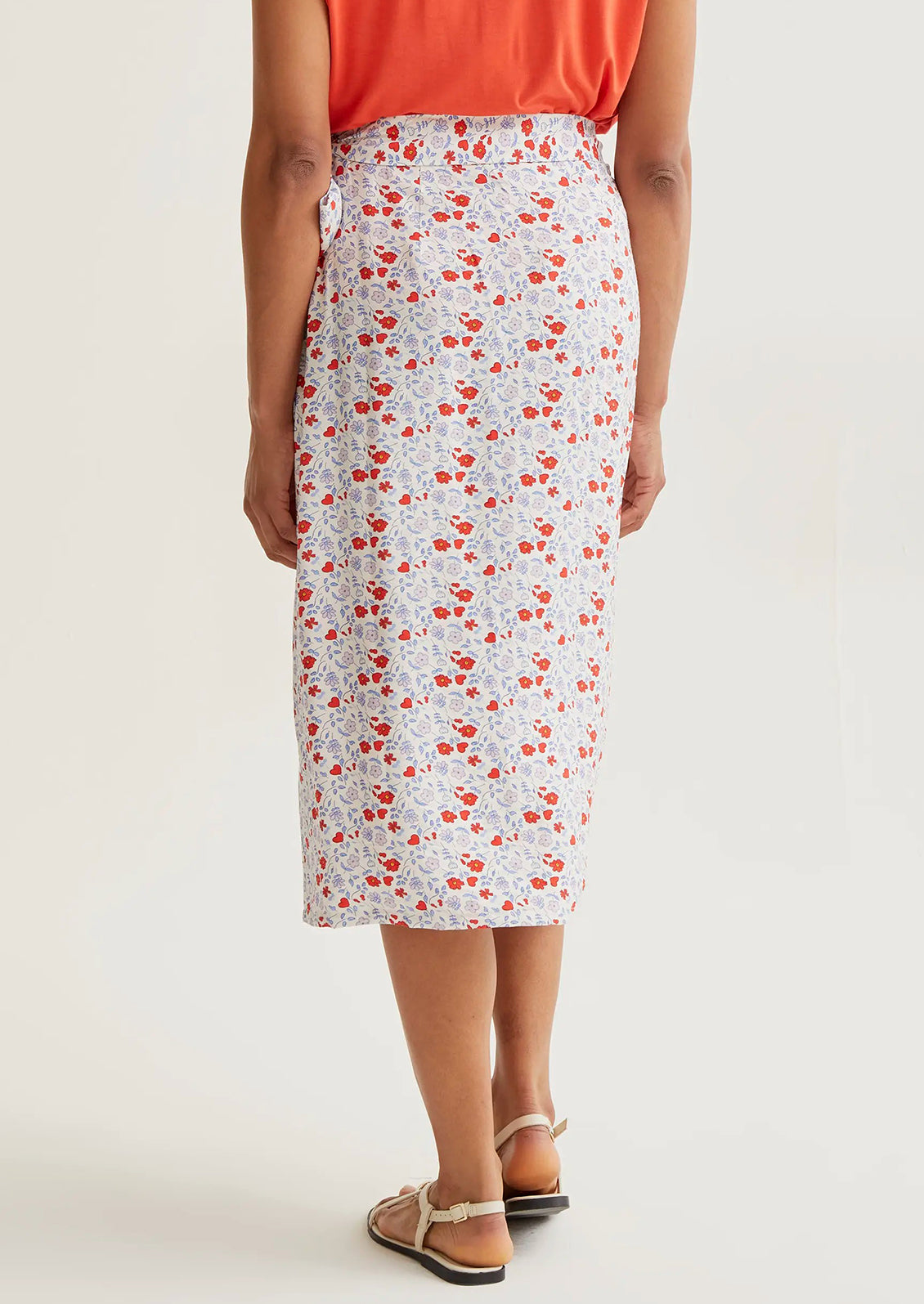 Person wearing a floral skirt with a plain background