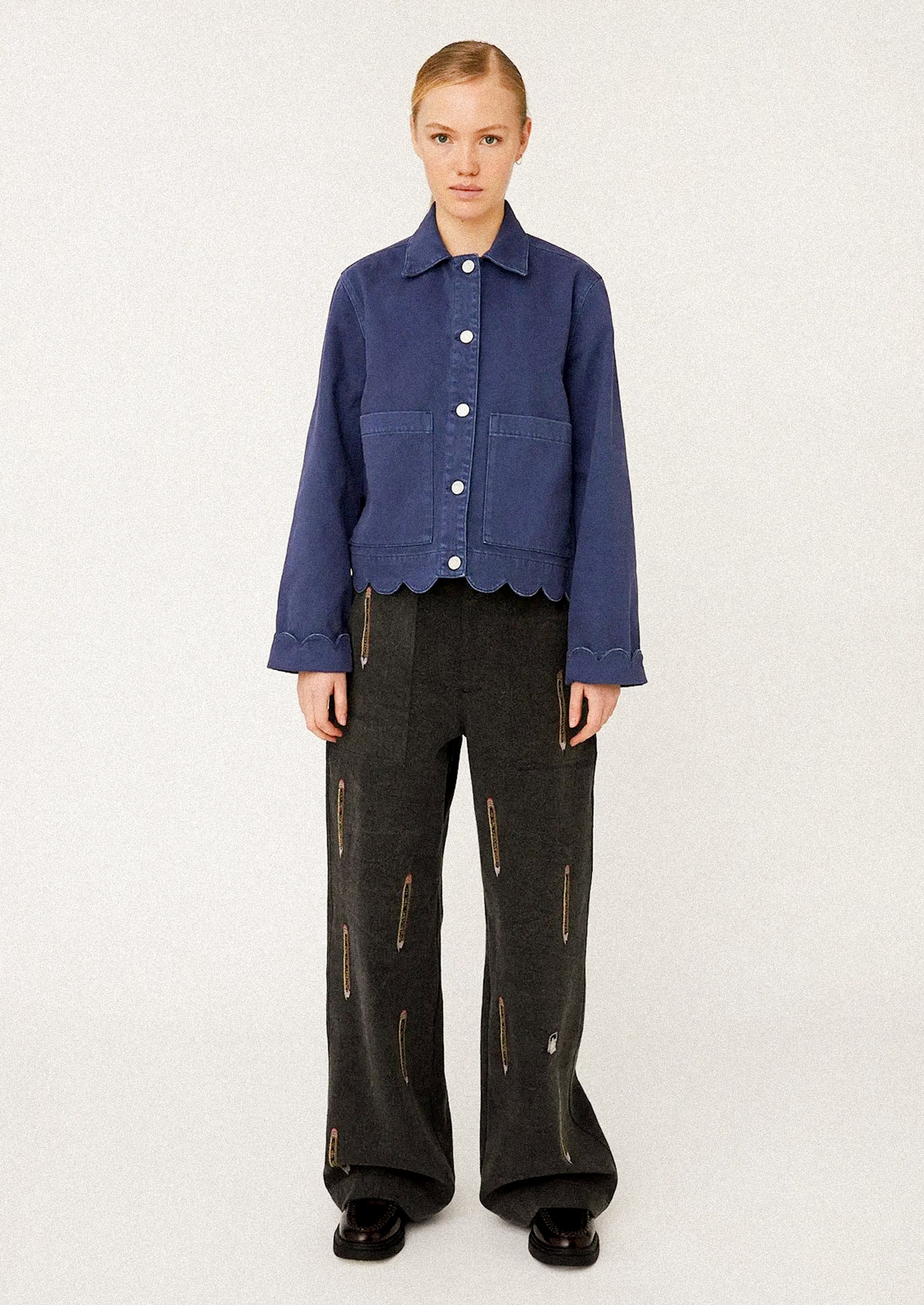 Person wearing a blue jacket with scalloped hem.