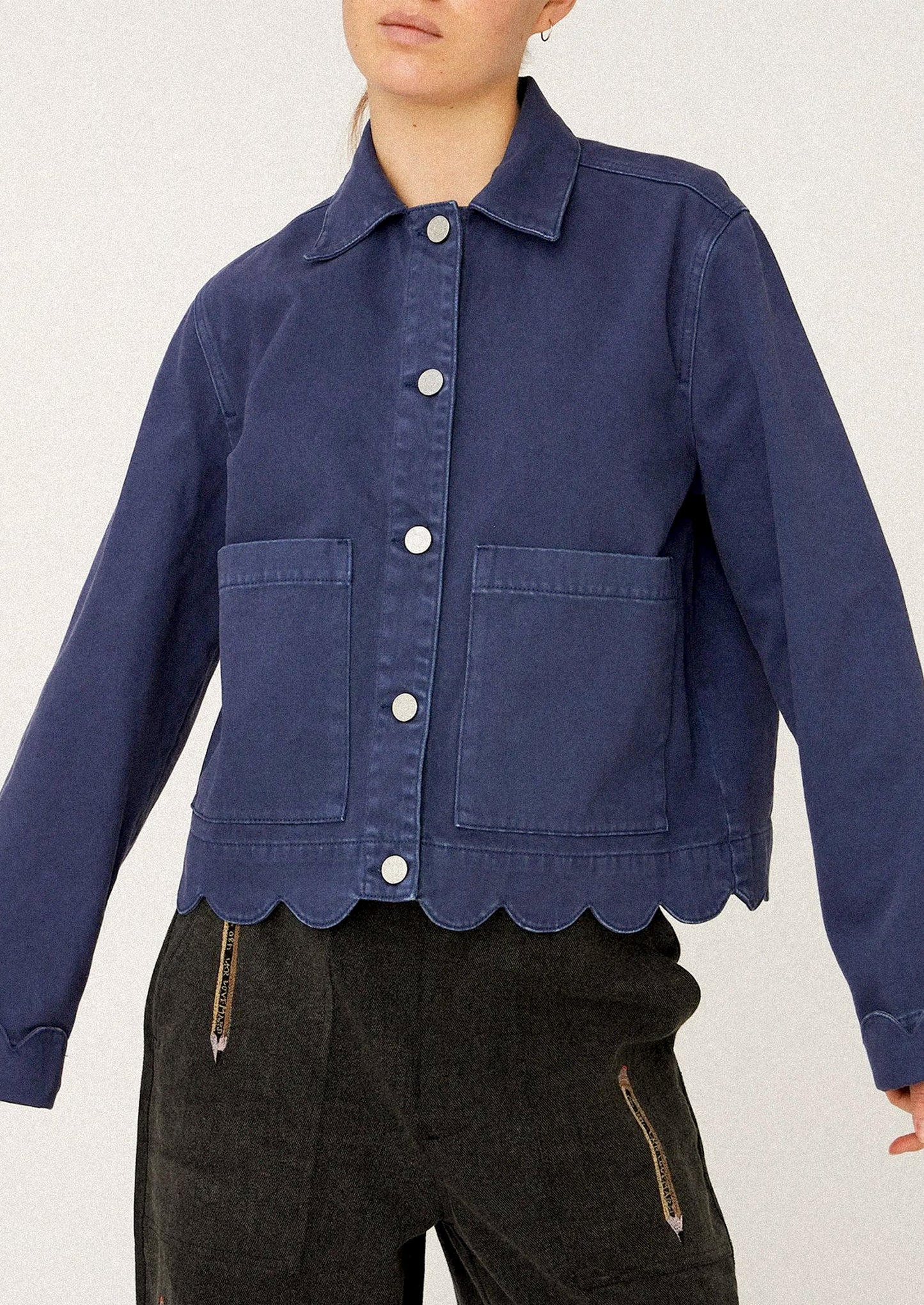 Person wearing a blue jacket with scalloped hem.