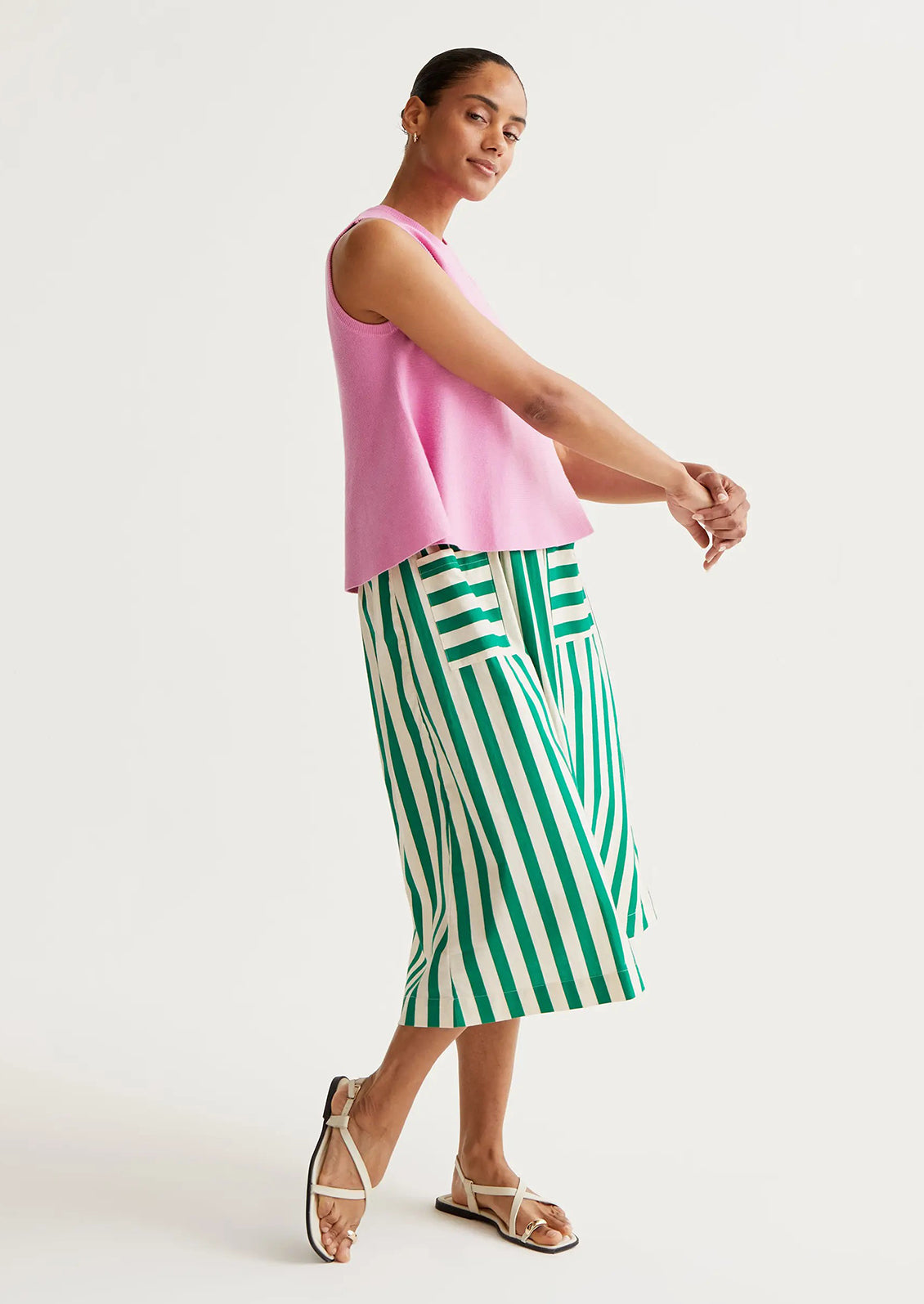Person wearing a green and white striped skirt on a plain background