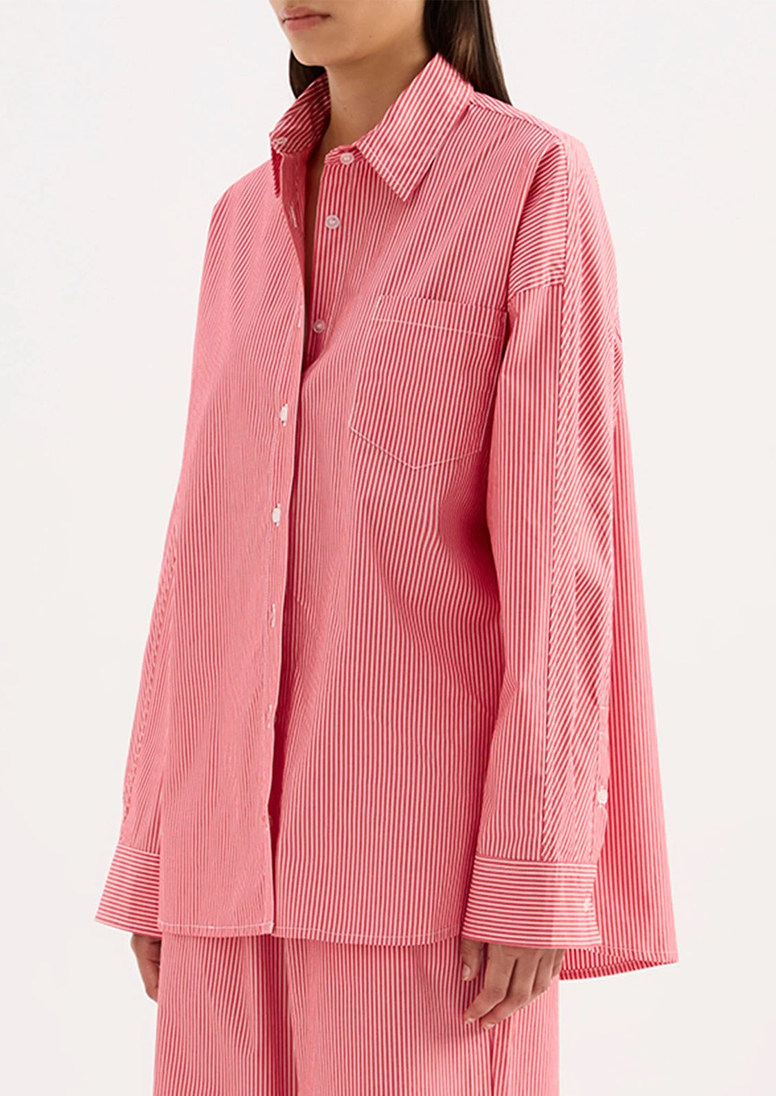 Person wearing a red striped shirt and pants on a white background