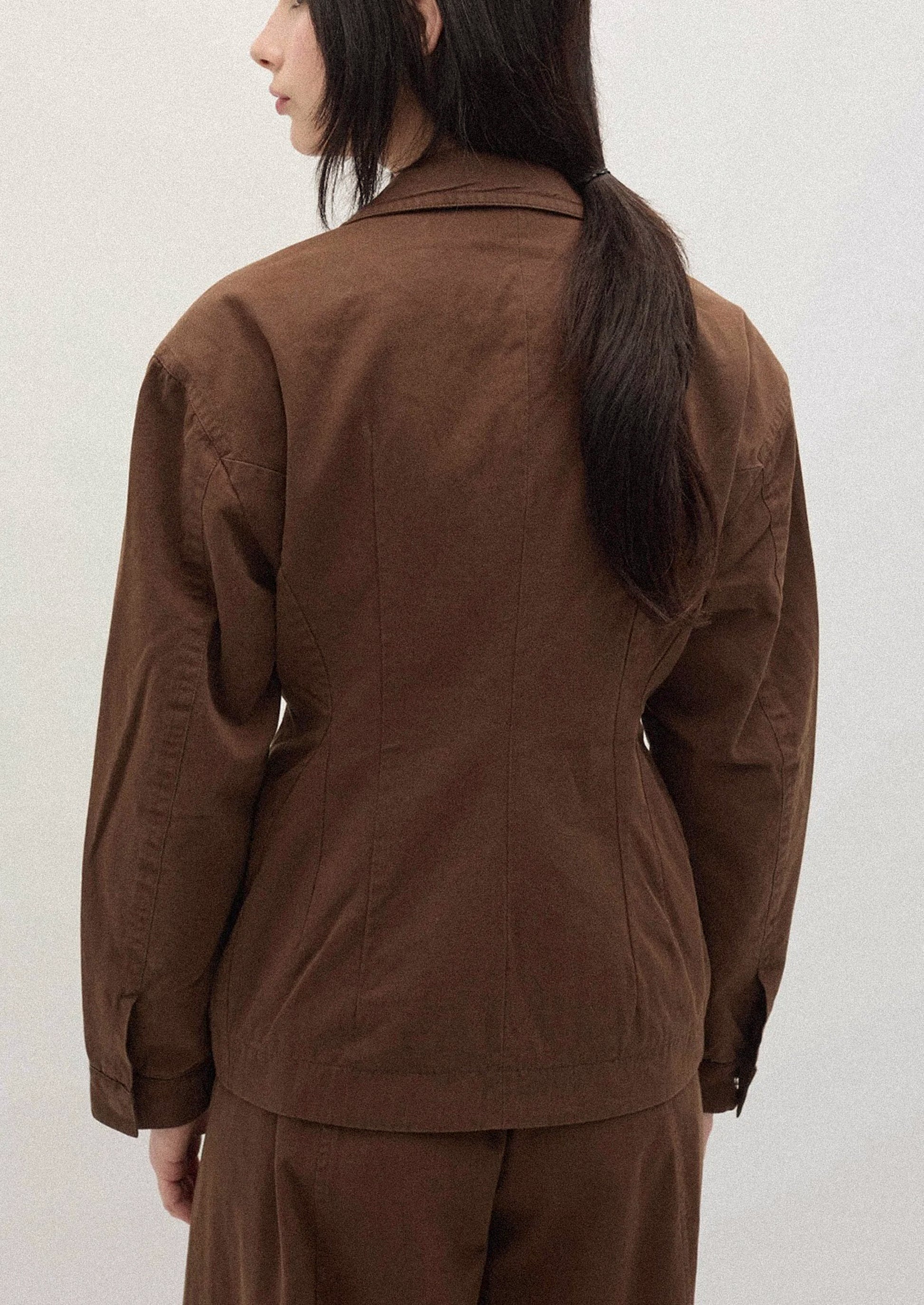 A person wearing a brown jacket