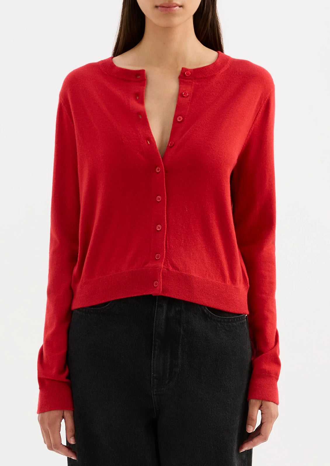 Red cardigan worn by a person on a white background