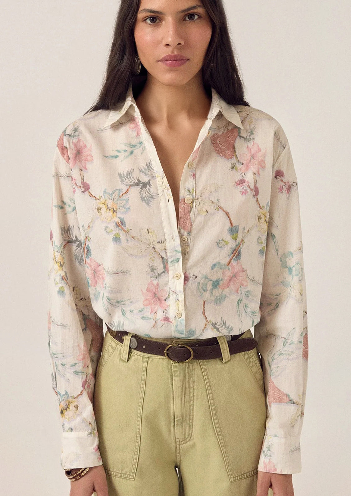 A person wearing a white floral print button front shirt.