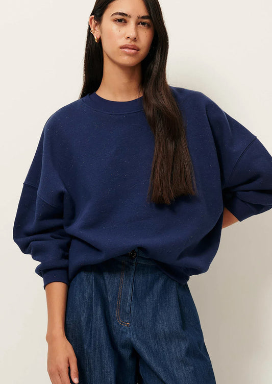 A person wearing a baggy navy blue sweatshirt.