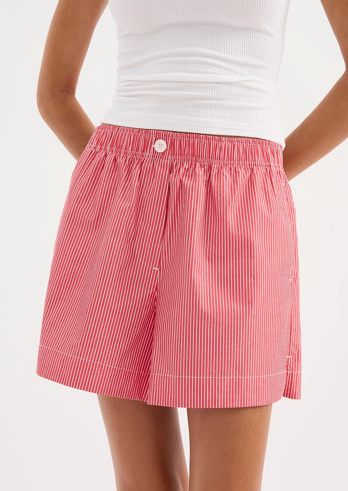 Red and white striped shorts worn by a person on a white background