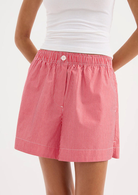 Red and white striped shorts worn by a person on a white background