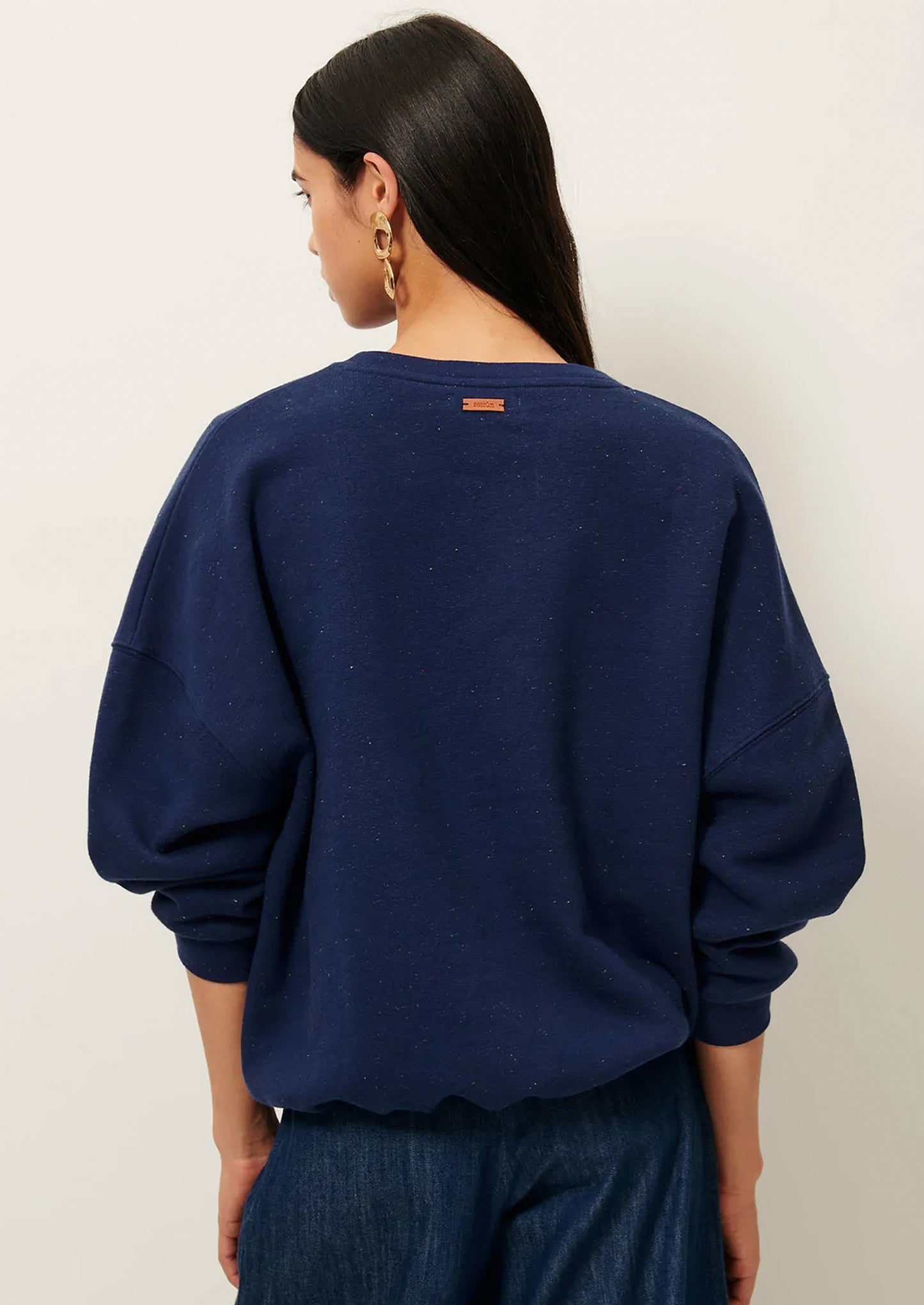 A person wearing a baggy navy blue sweatshirt.