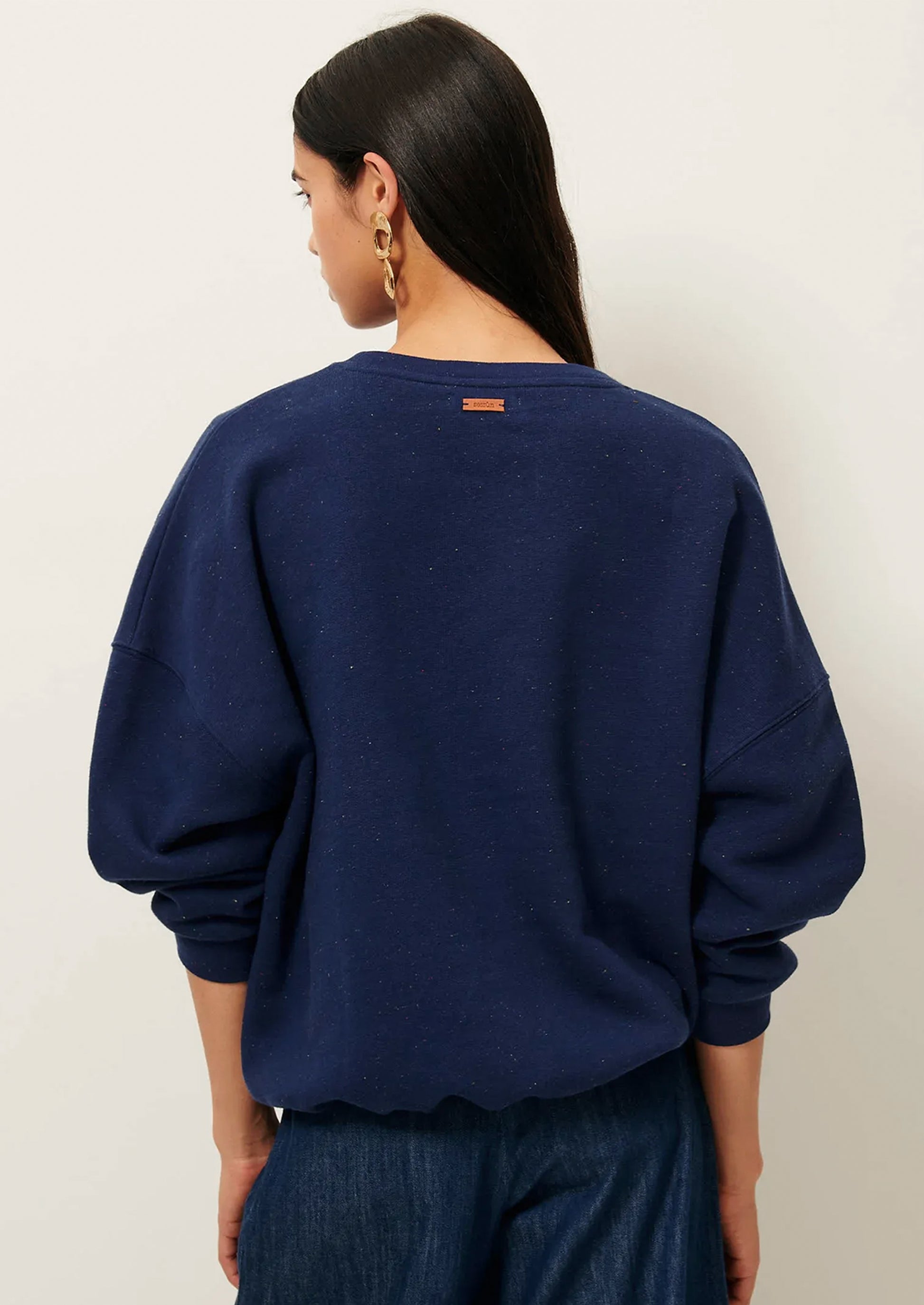 A person wearing a baggy navy blue sweatshirt.