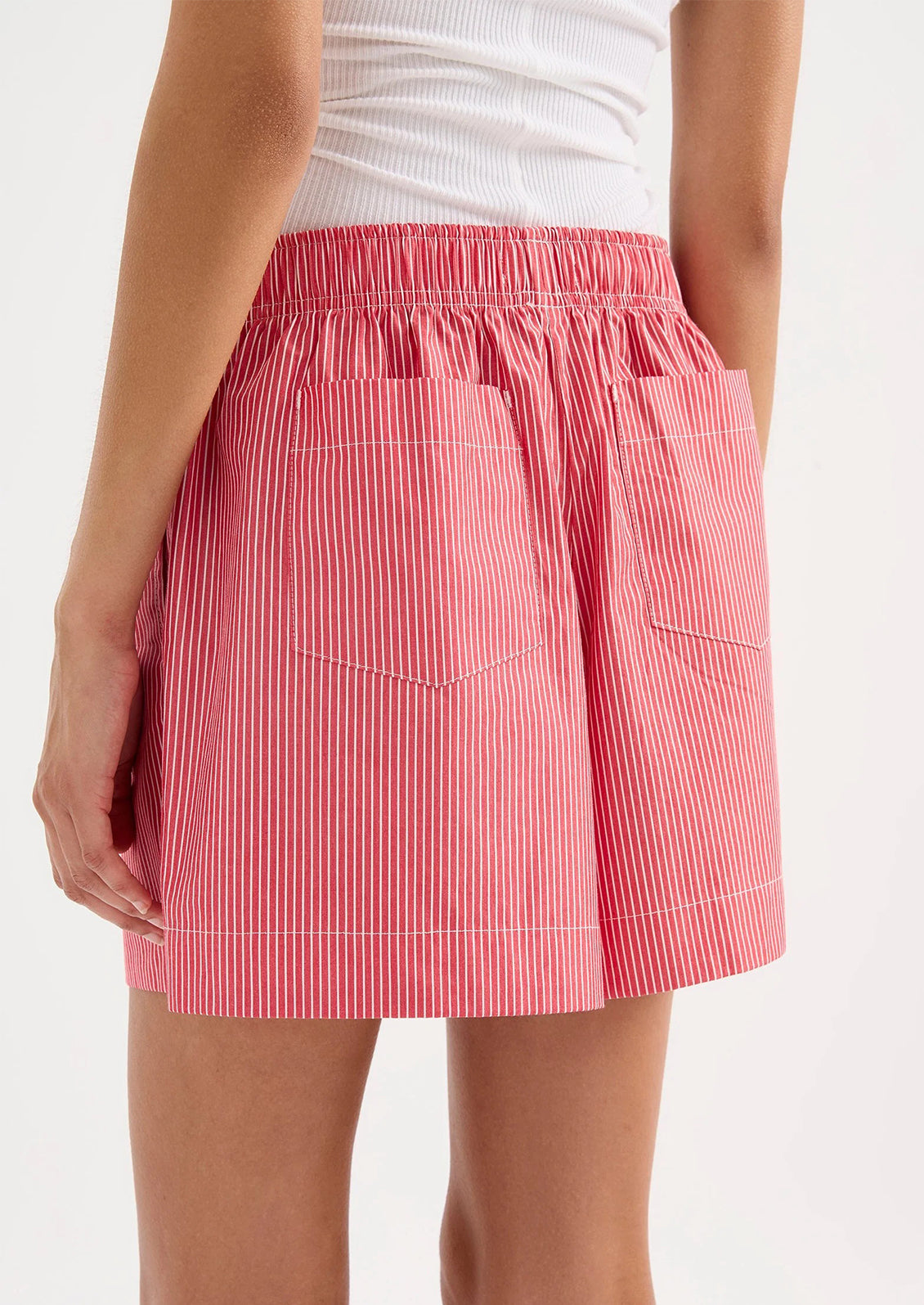 Red and white striped skirt worn by a person on a white background