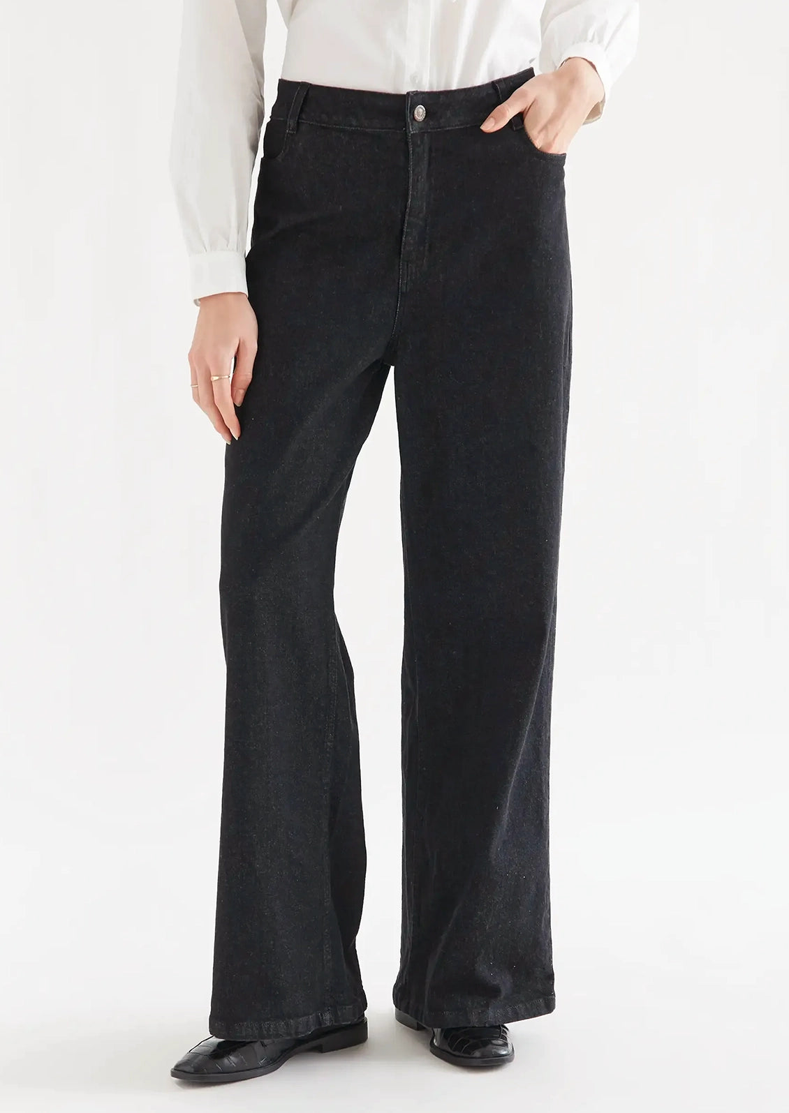 A person wearing a pair of black denim jeans.