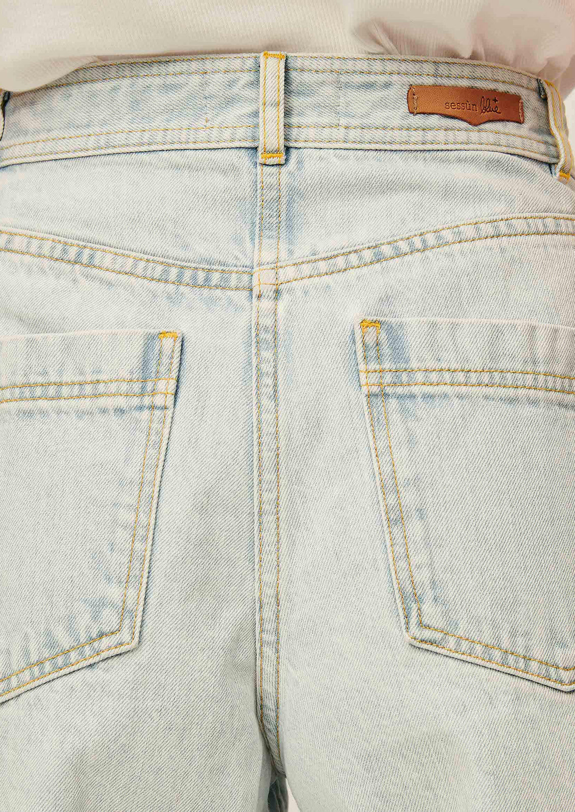 A person wearing a pair of denim bermuda shorts in light blue stonewash.