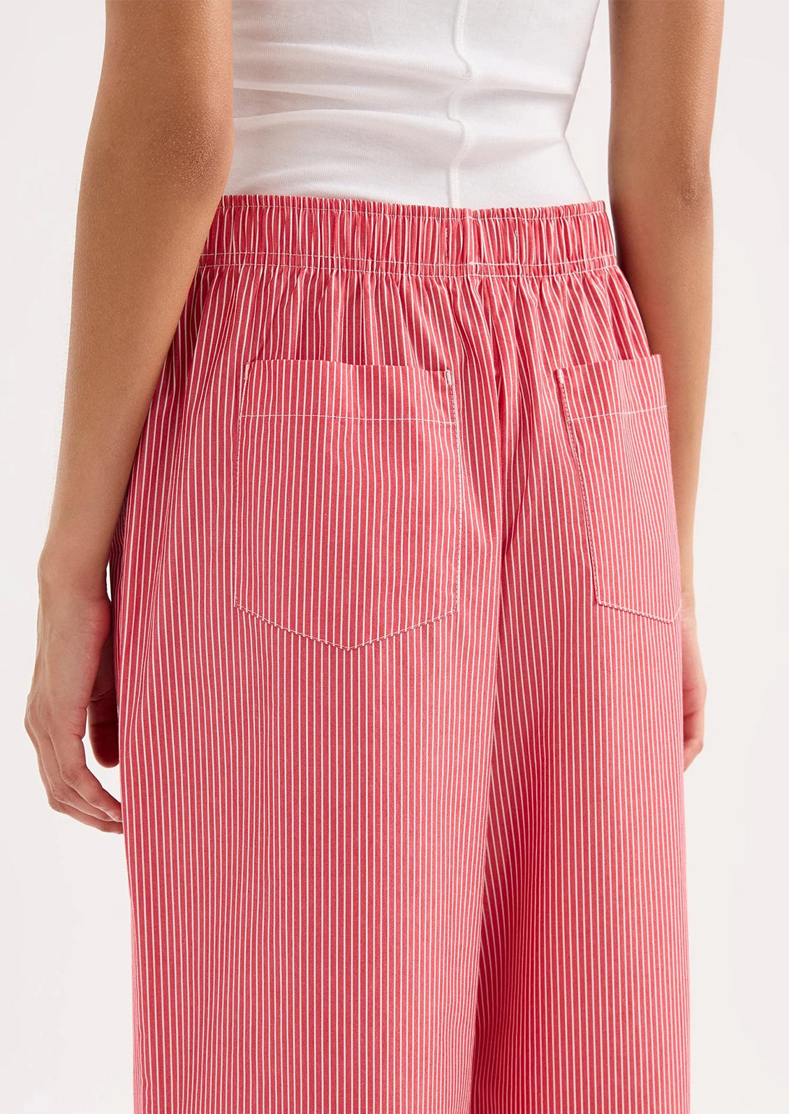 Red striped pants worn by a person on a white background