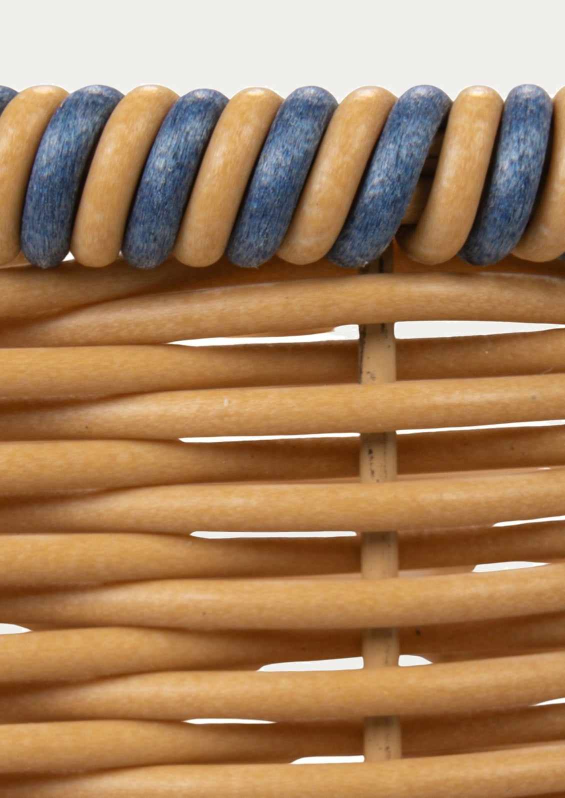 Close-up of a woven basket with blue and brown wooden slats.