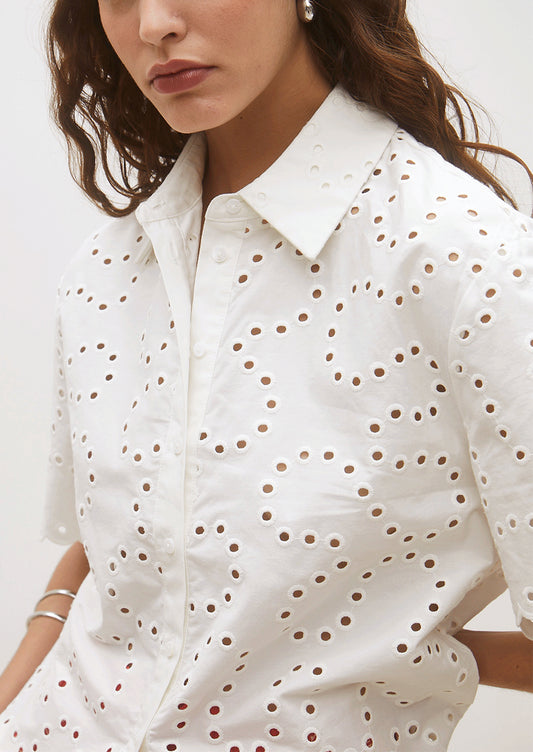 White shirt with a subtle pattern worn by a person on a white background