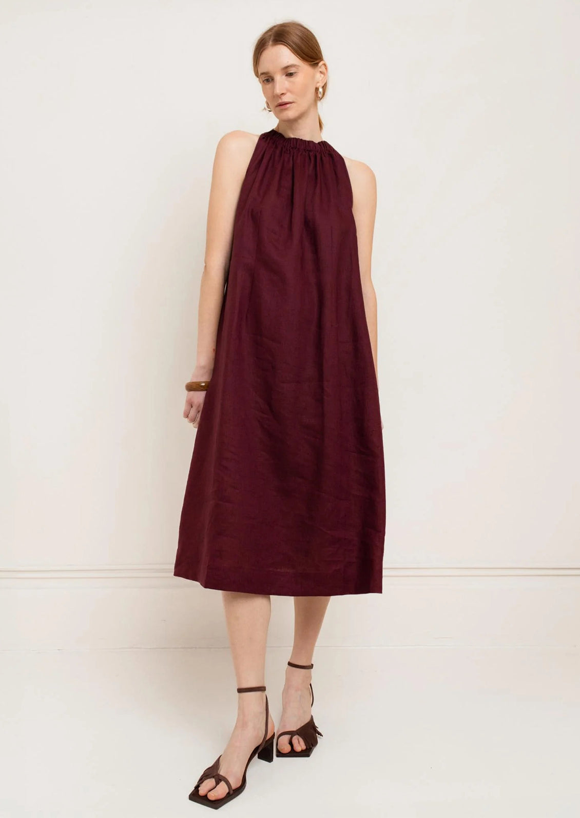 Woman wearing a burgundy dress against a white background