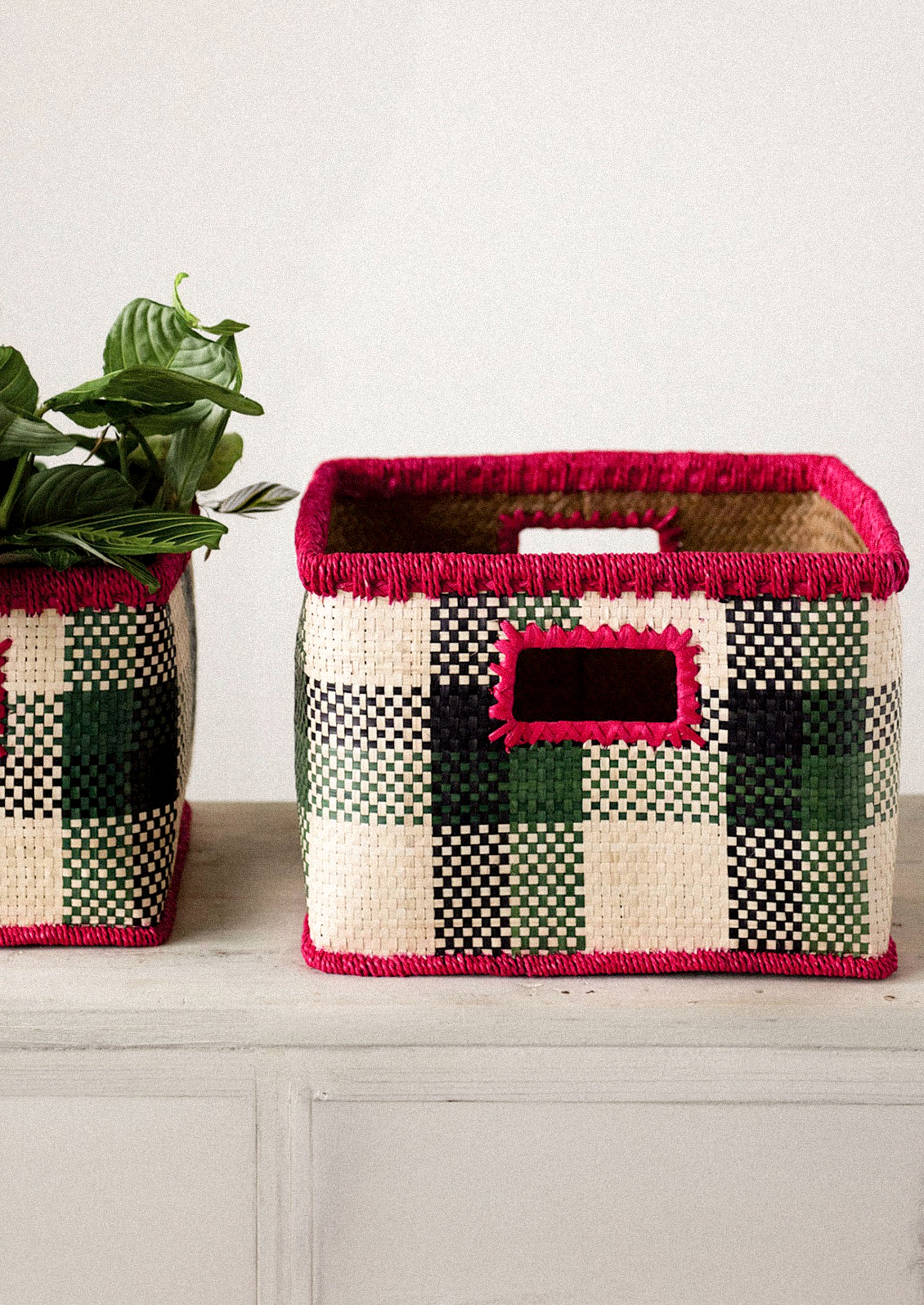 Two woven baskets with a checkered pattern on a wooden surface.