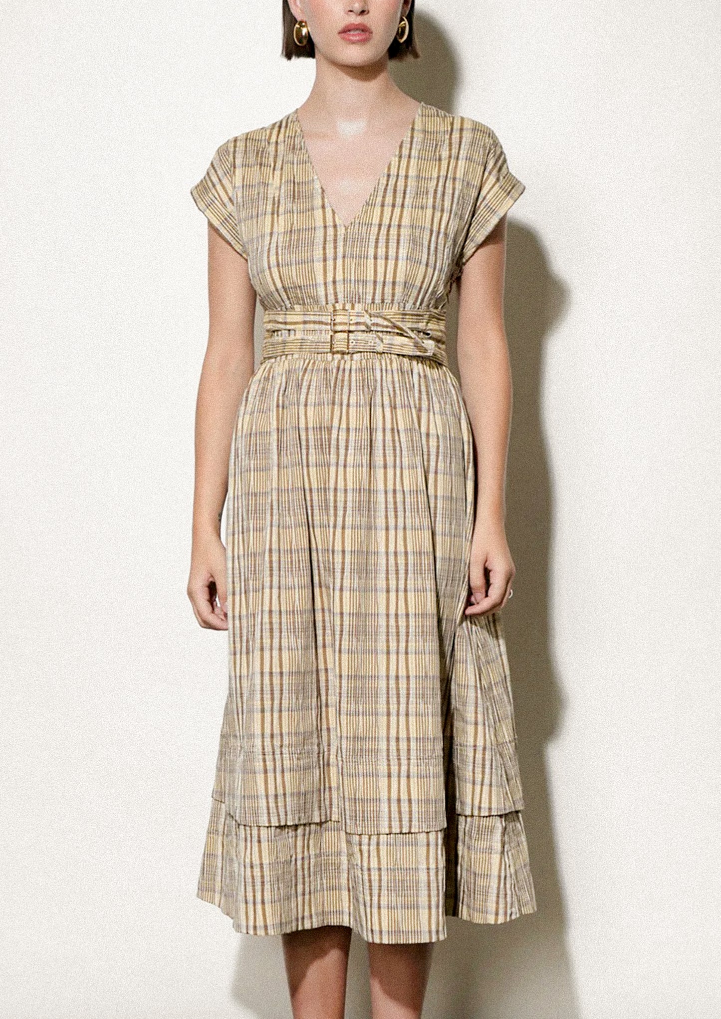 Woman wearing a plaid dress against a white background