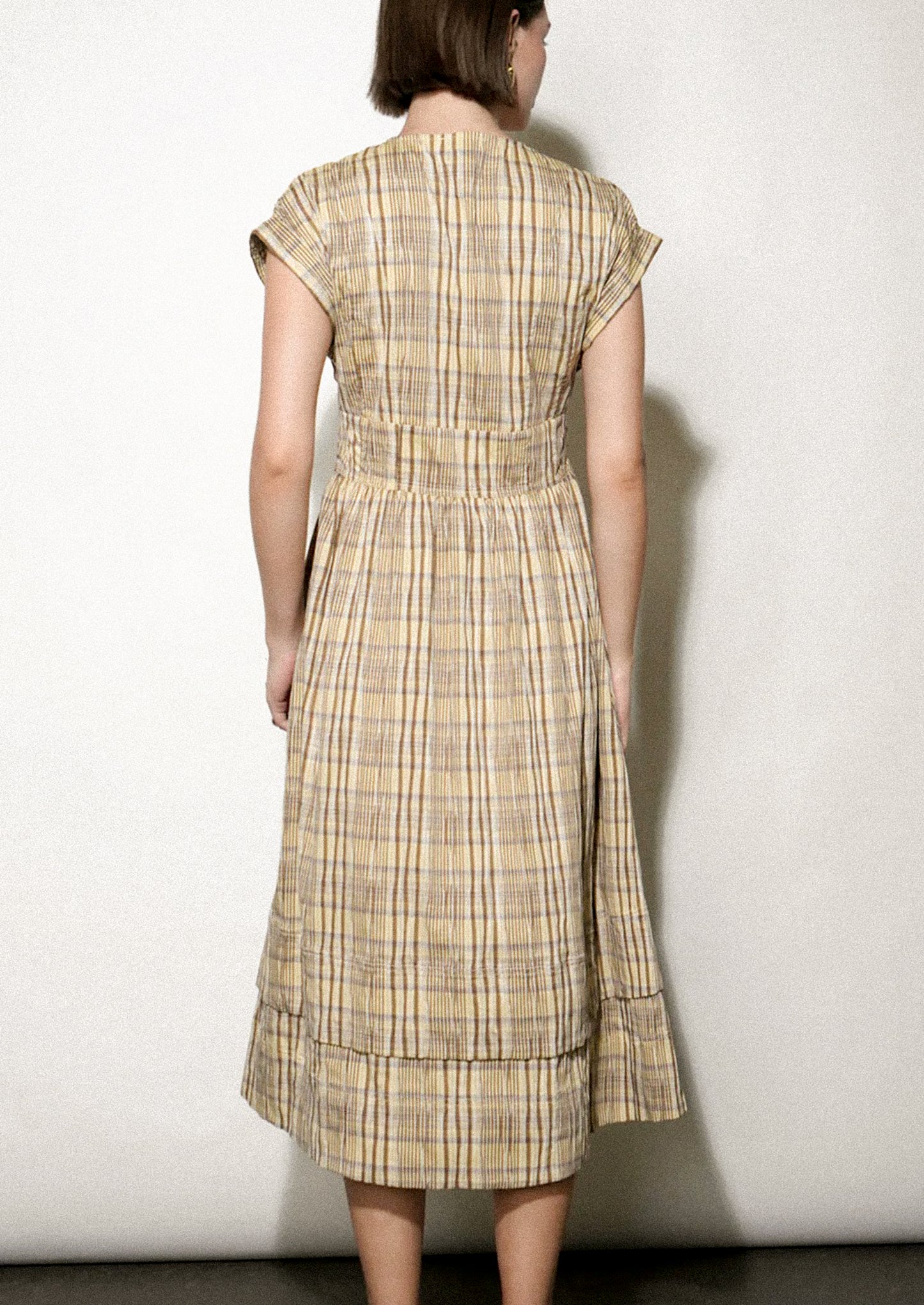 Woman wearing a plaid dress against a white background