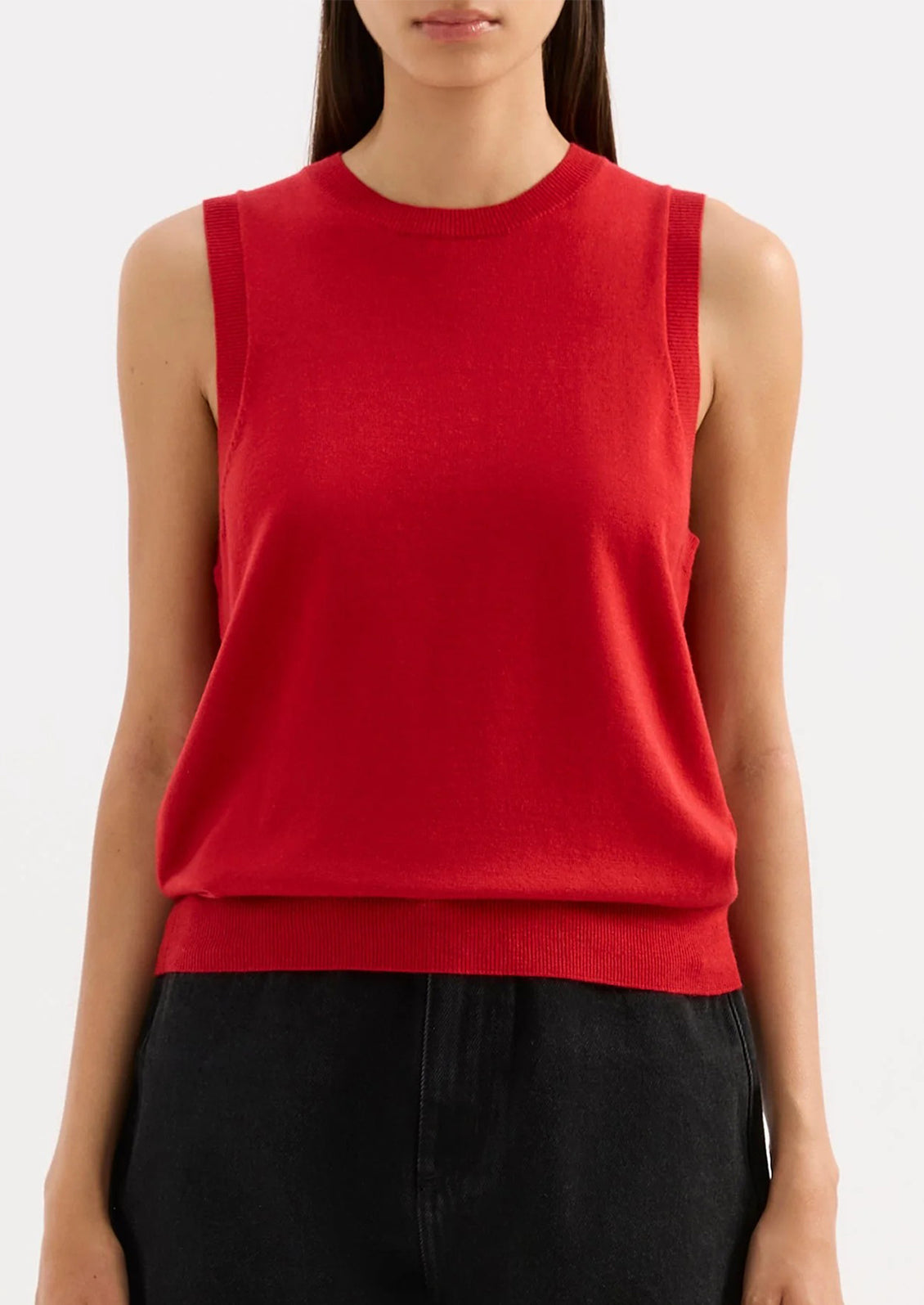 Red sleeveless top worn by a person on a white background