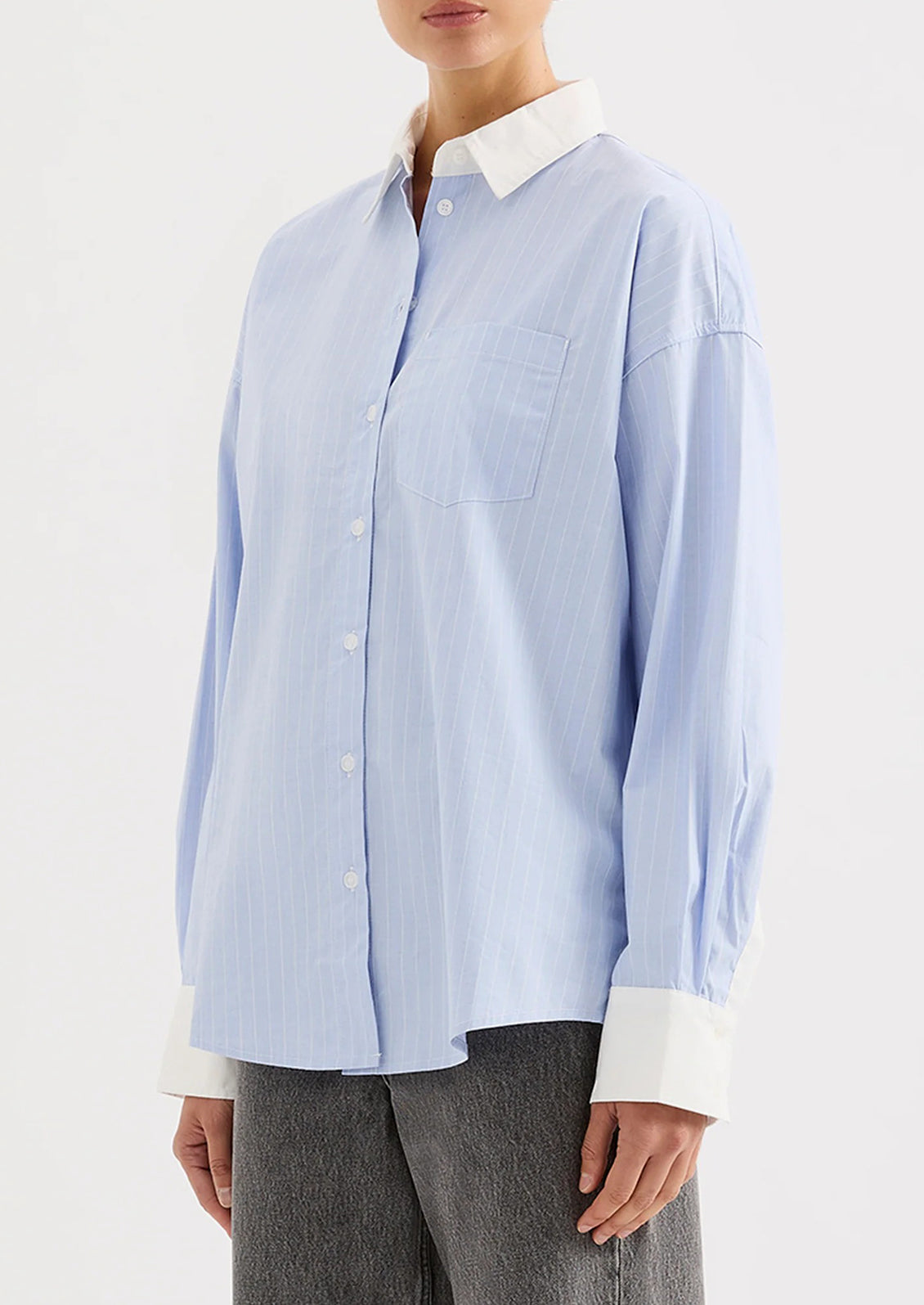 Light blue striped shirt with white collar and cuffs worn by a person on a white background.
