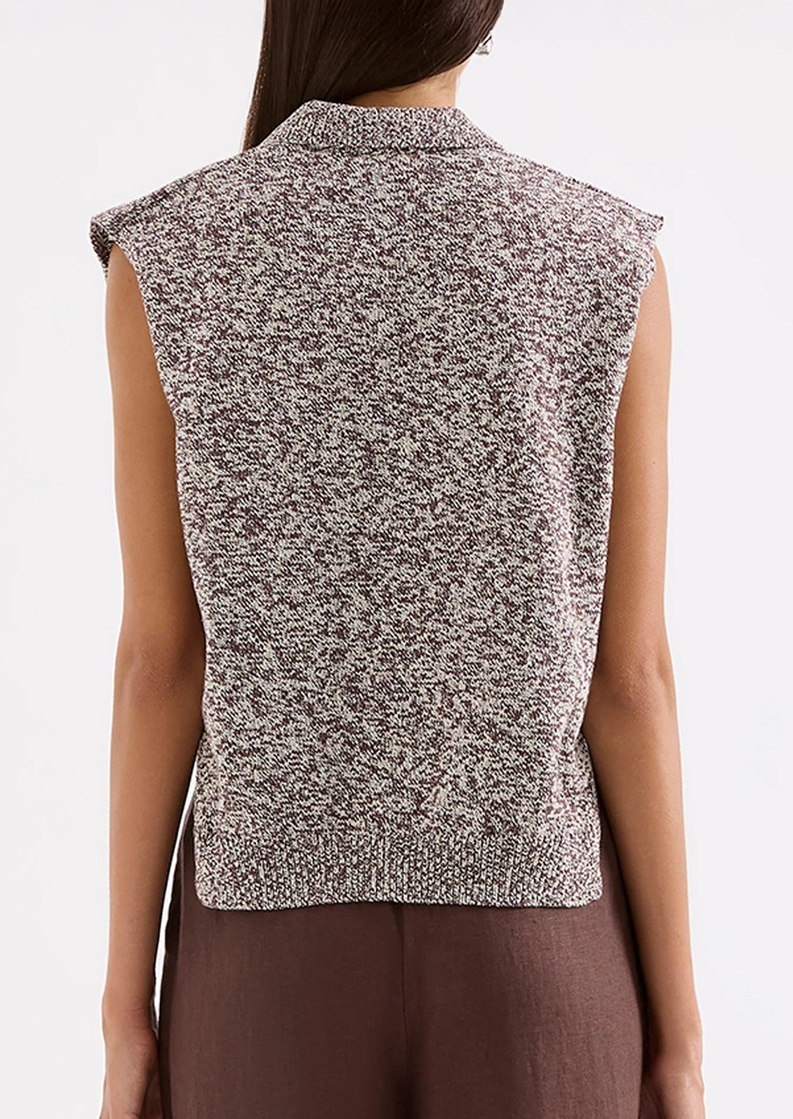 Person wearing a sleeveless patterned top with a plain background