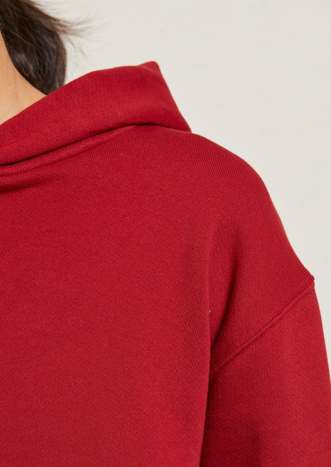 A woman wearing a bright red hoodie sweatshirt.