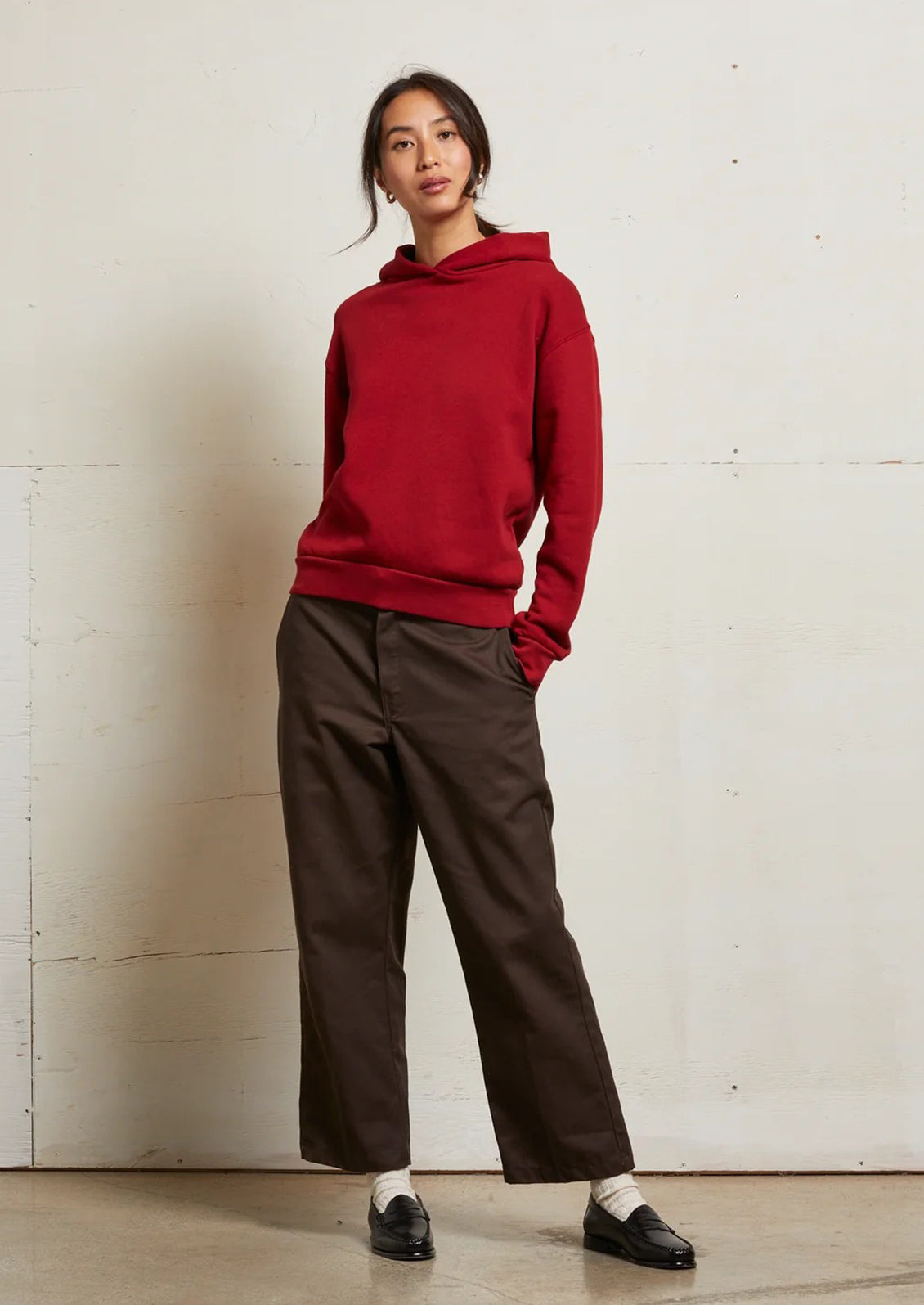 A woman wearing a bright red hoodie sweatshirt.