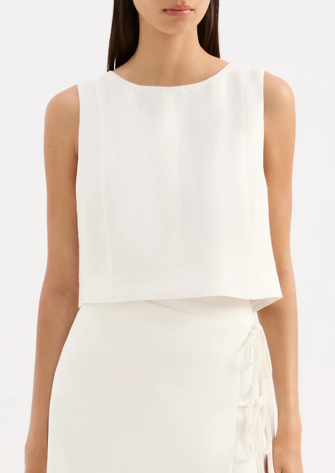 White sleeveless top worn by a model on a white background