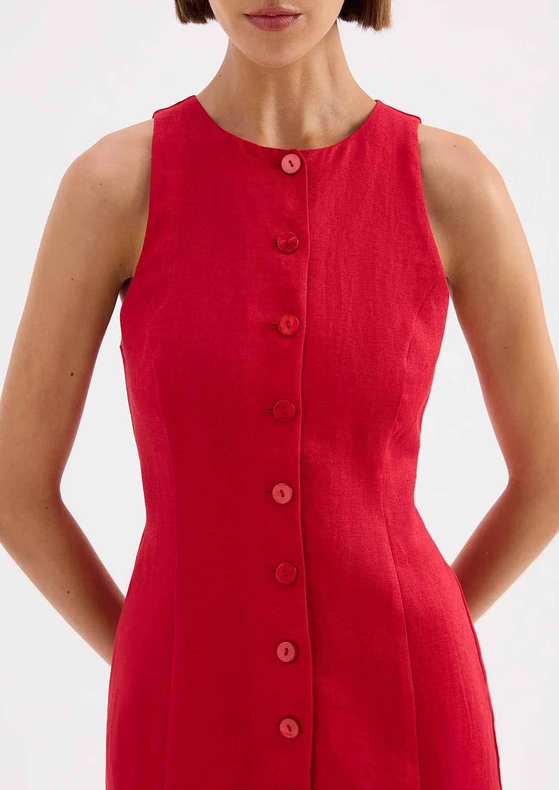 Red sleeveless dress with buttons on a white background