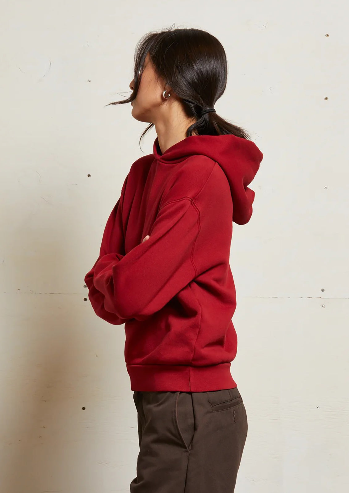 A woman wearing a bright red hoodie sweatshirt.