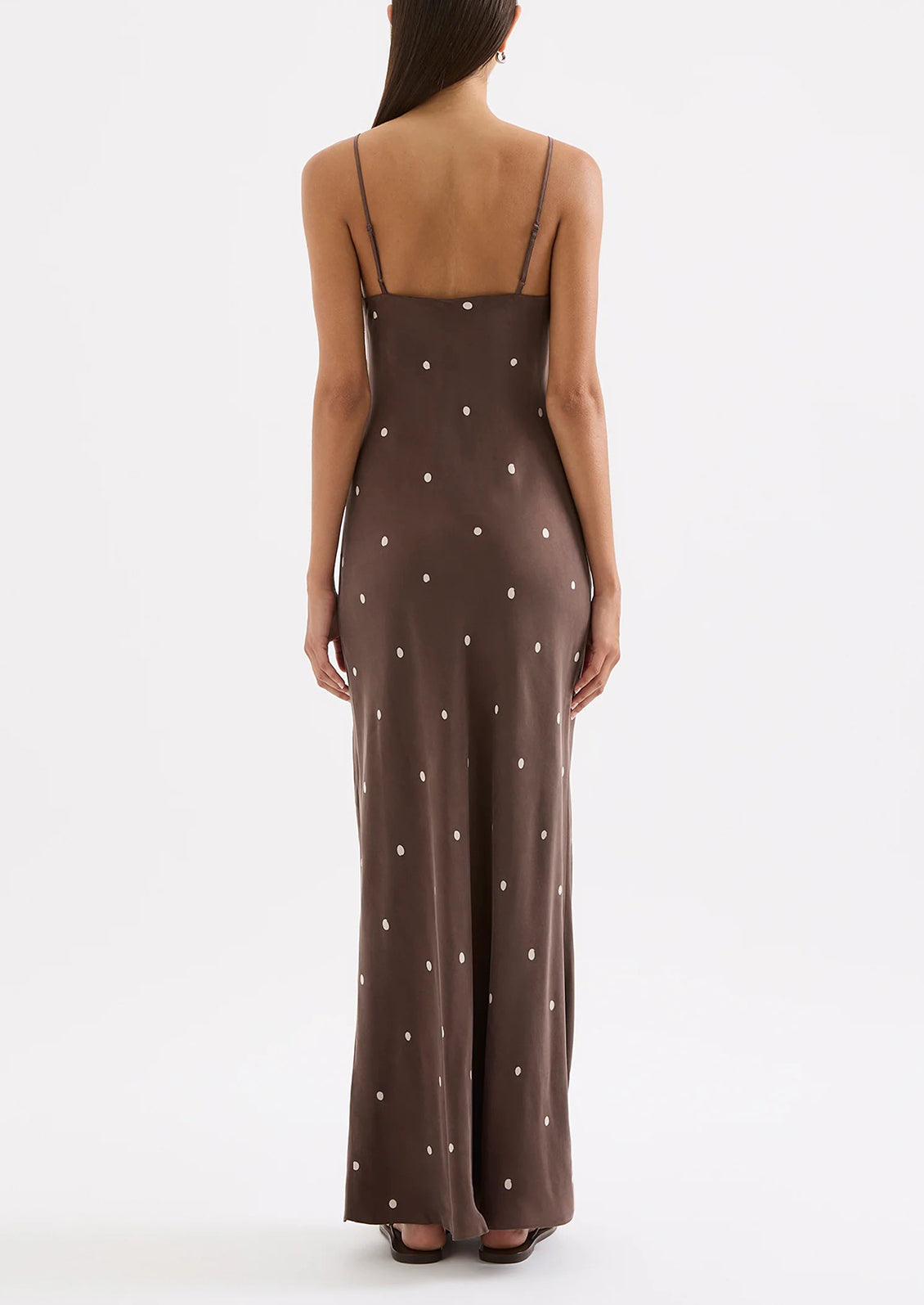 Brown slip dress with white polka dots on a white background