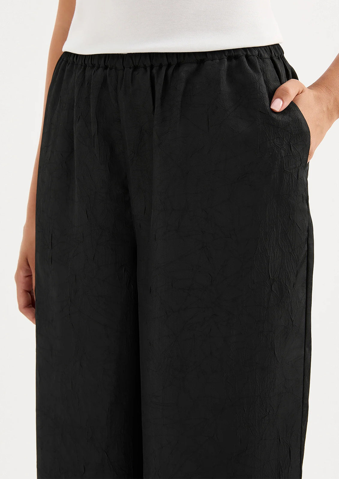 Black wide-leg pants worn by a person on a white background