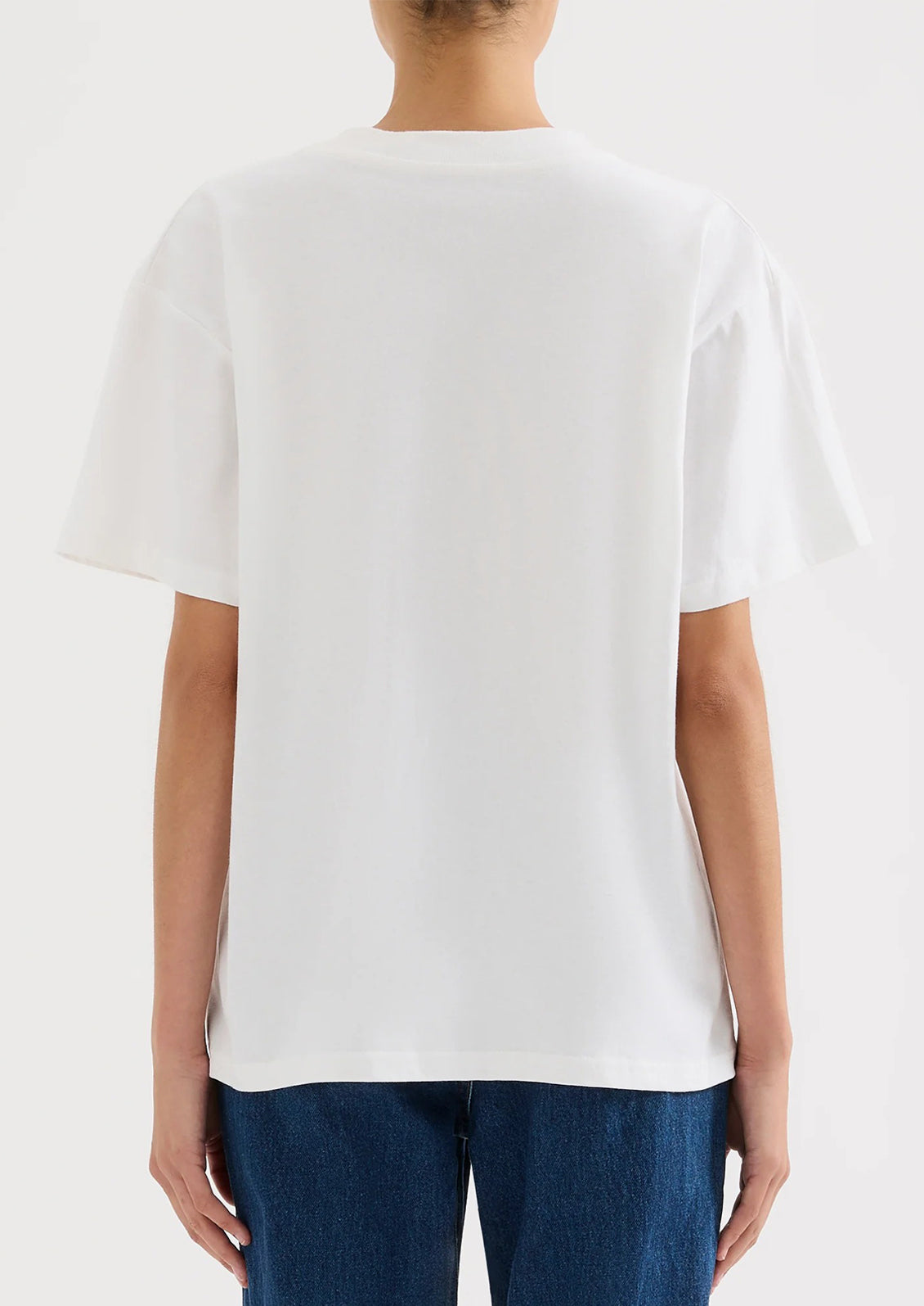 A person wearing an oversized fit white t-shirt.
