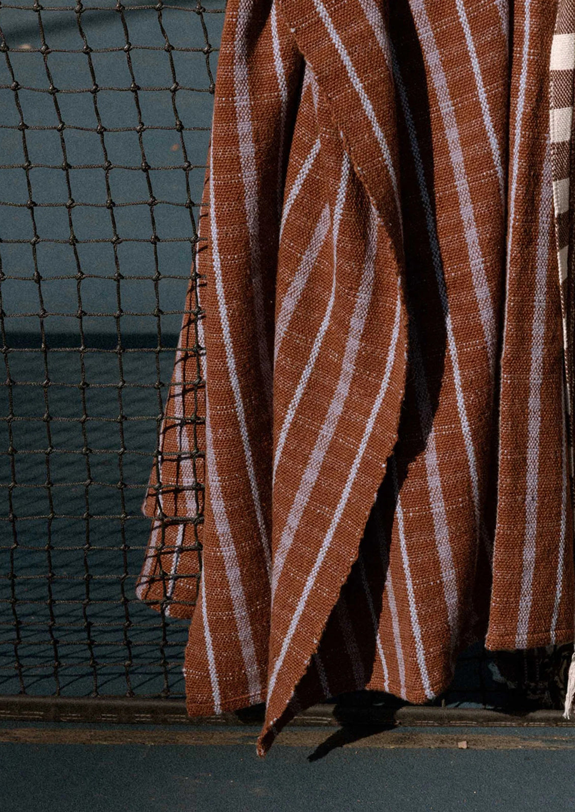 A striped blanket in brown and purple.