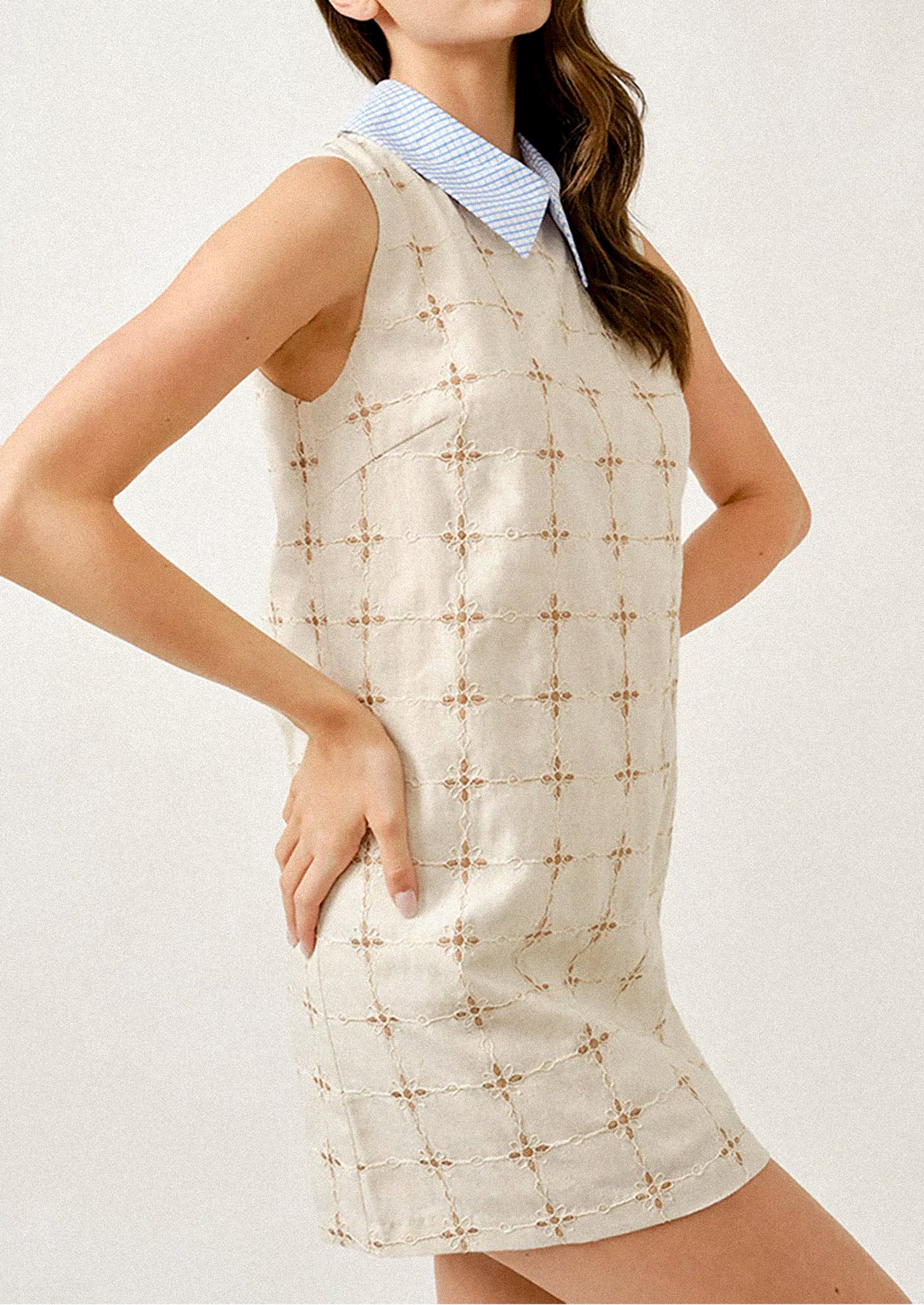 Woman wearing a sleeveless dress with a geometric pattern on a white background