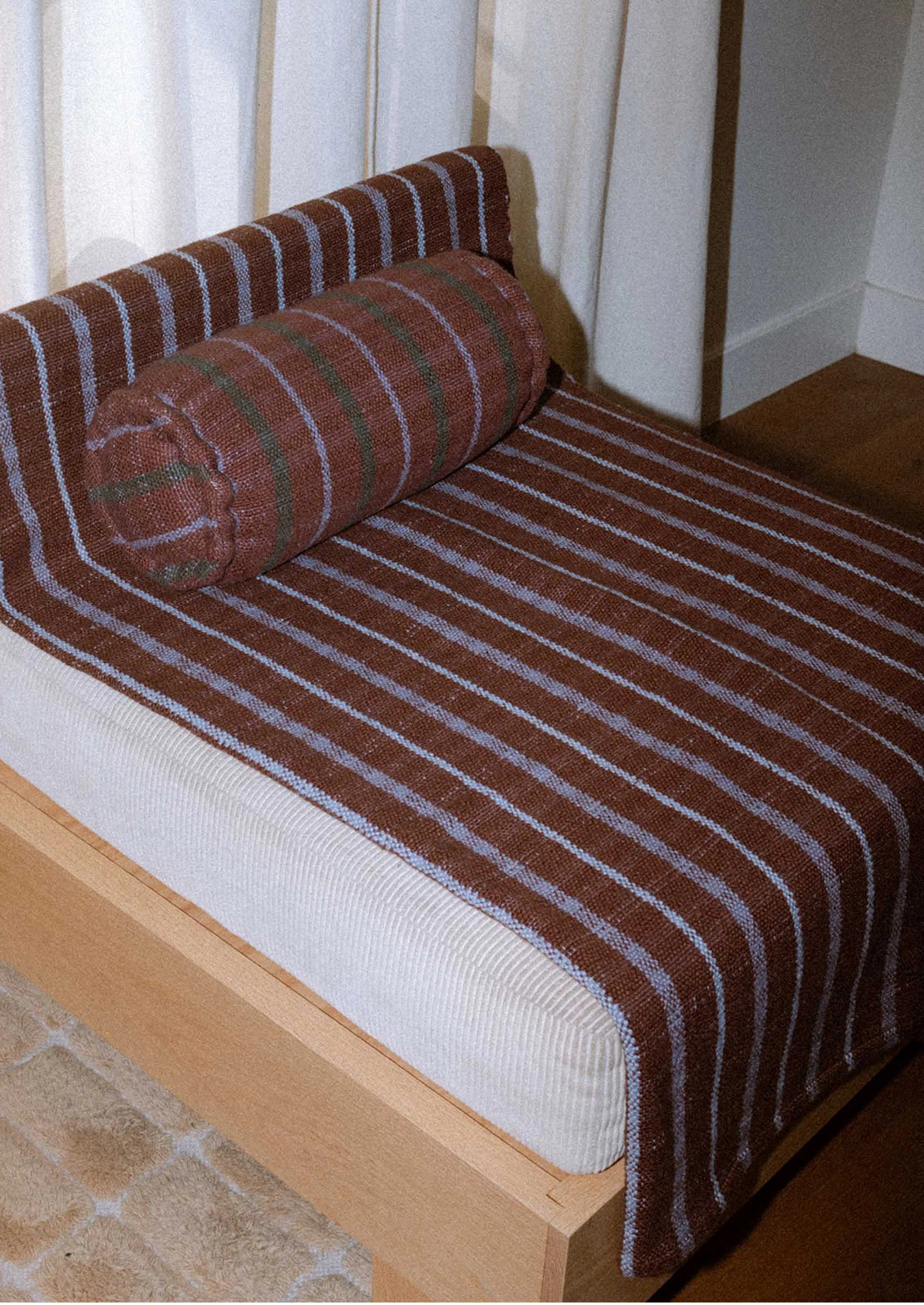 A striped blanket in brown and purple.