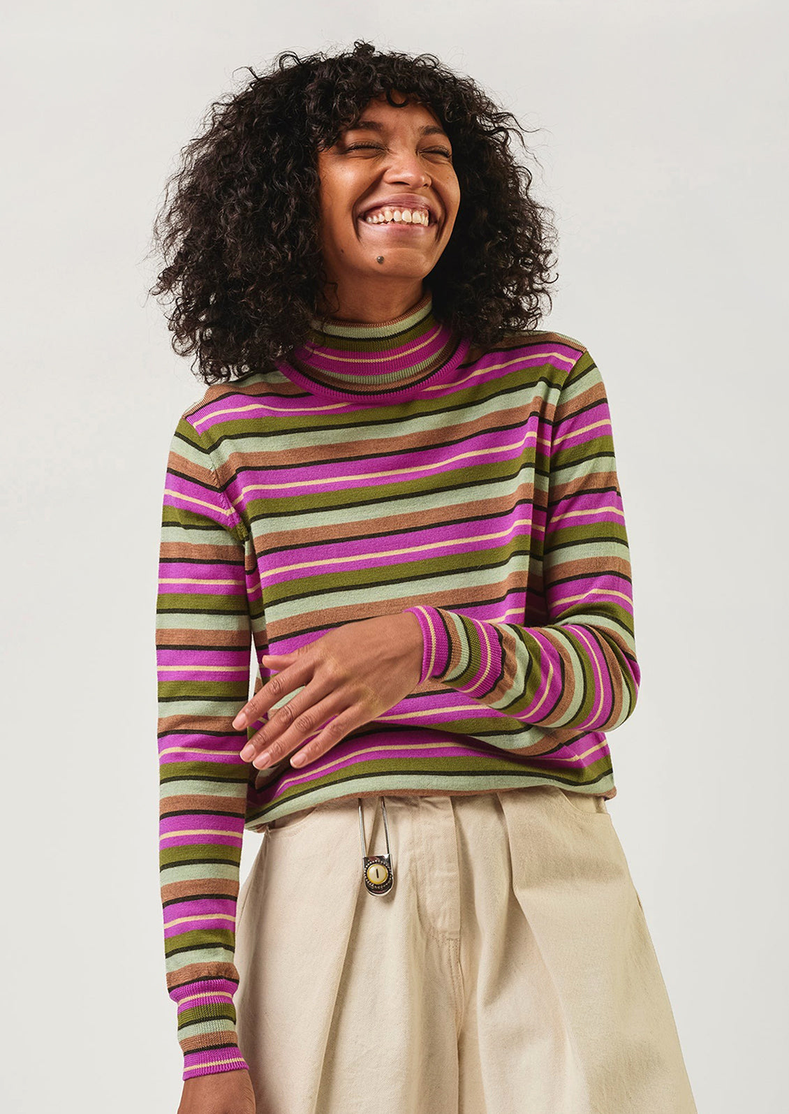 Person wearing a striped sweater with a plain background