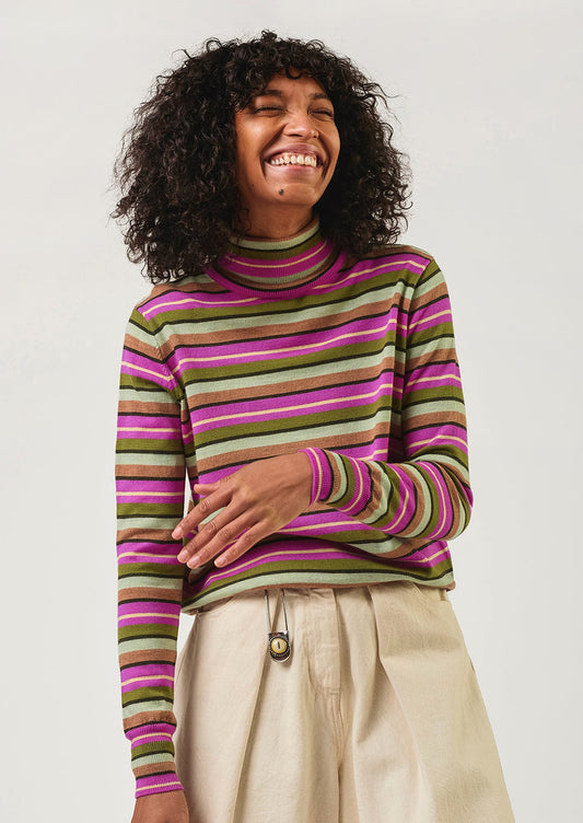 Person wearing a striped sweater with a plain background
