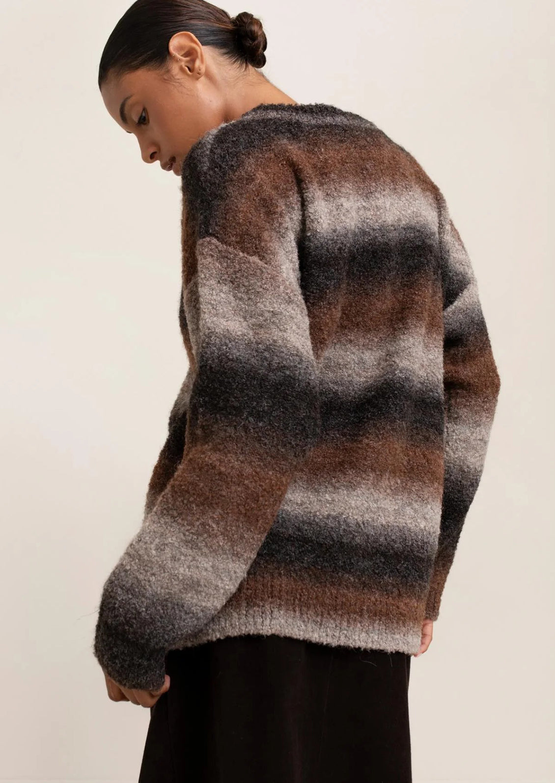 Person wearing a patterned sweater with a neutral background