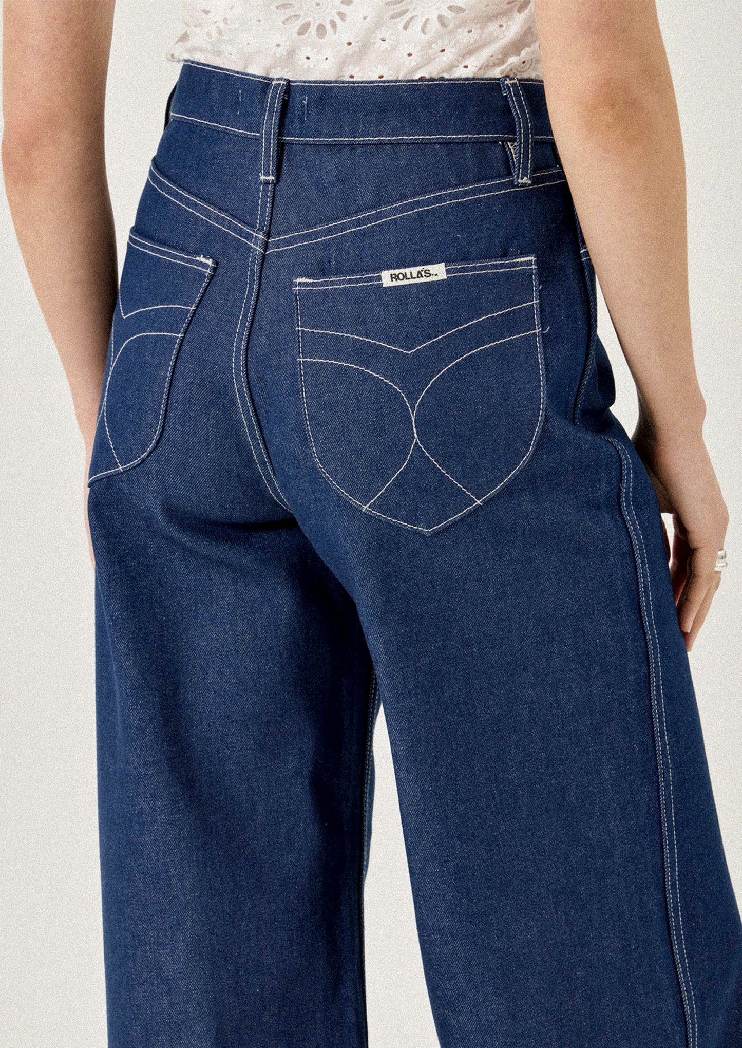 Blue jeans with a brand label on a plain background