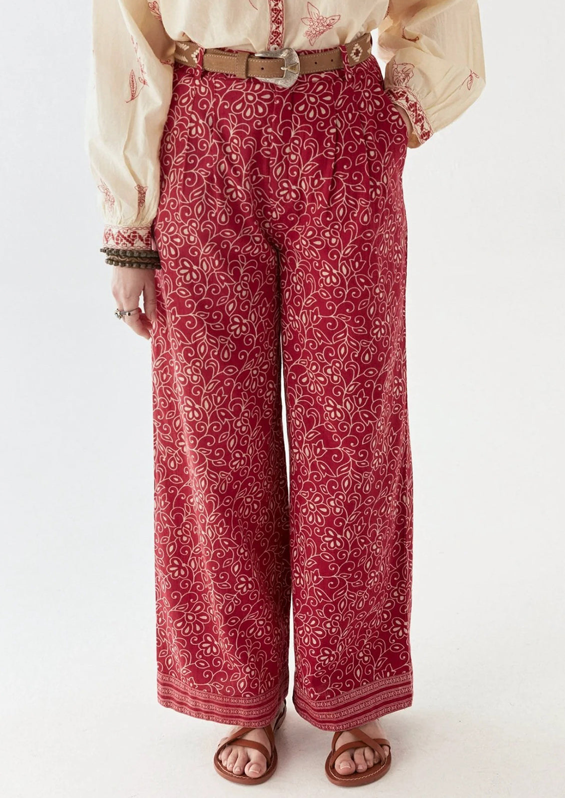A person wearing a pair of red paisley patterned pants.