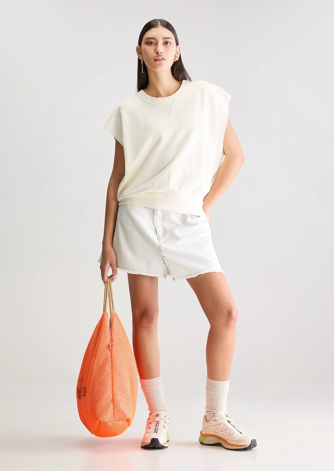 A woman wearing an ivory cut-off sweatshirt.