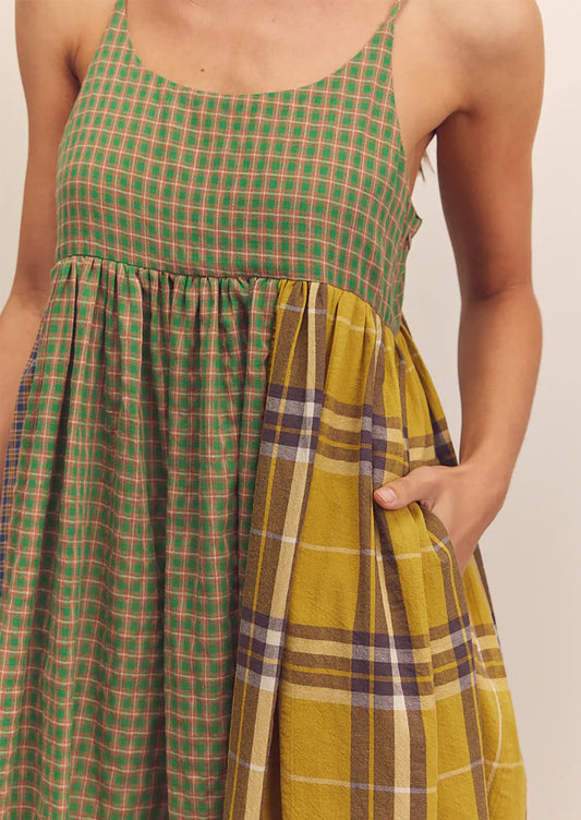 A person wearing a long tank dress in mixed color plaid pattern.