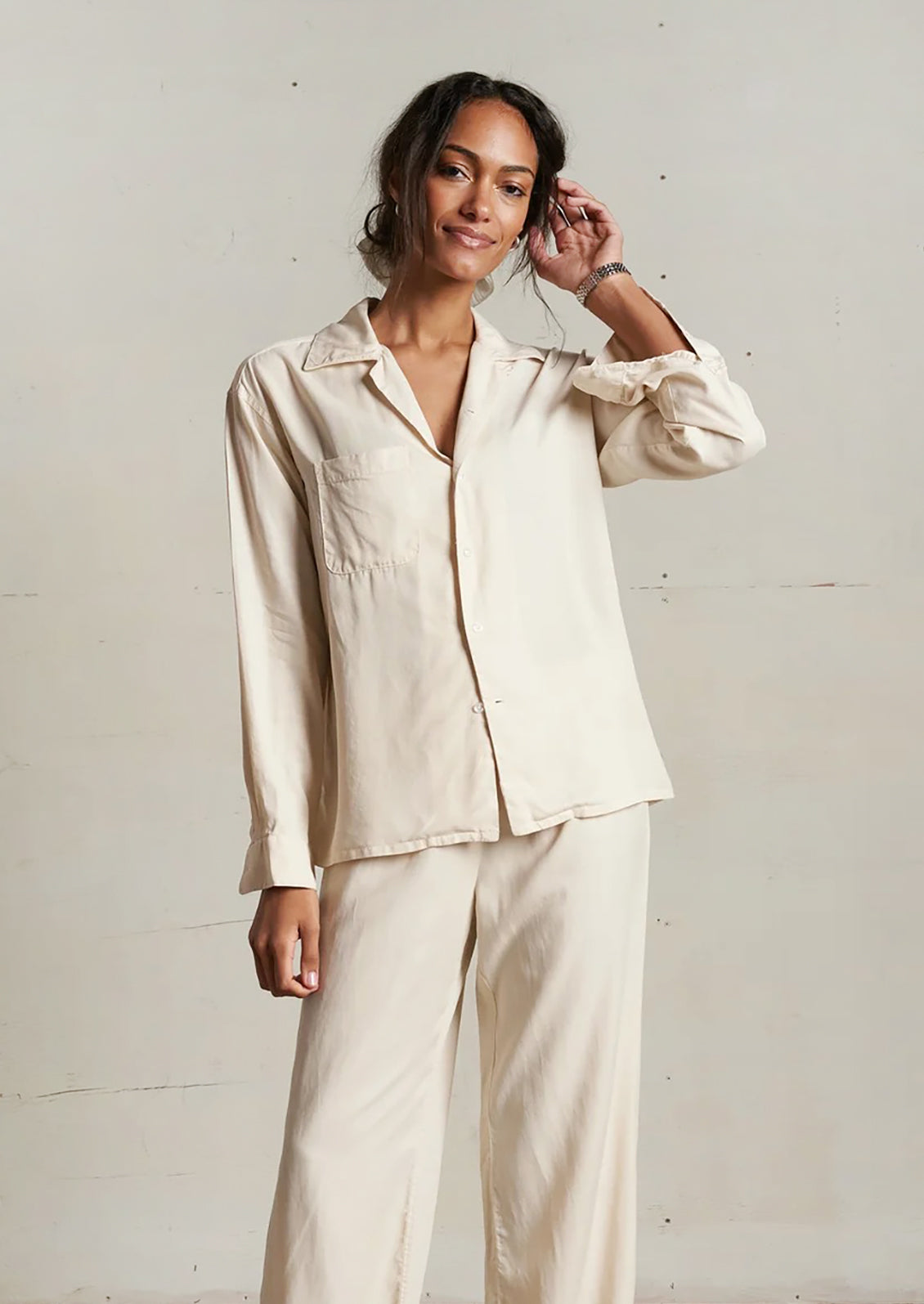 Woman wearing a beige outfit against a plain background